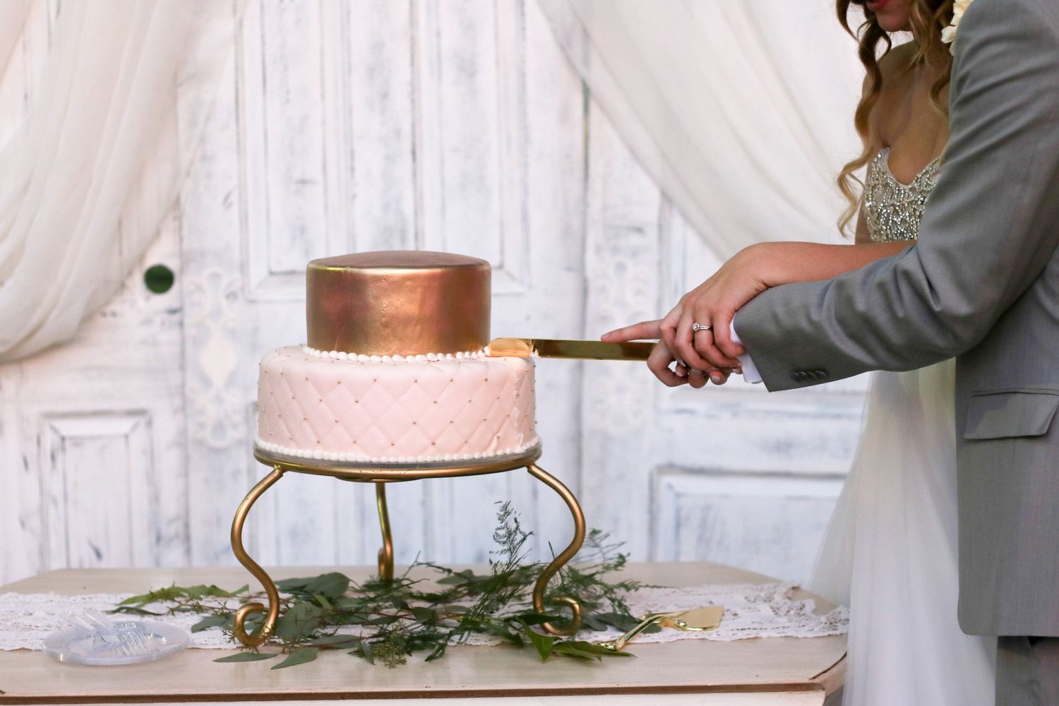 Wedding cake cutting sequence with rustic white backdrop.
