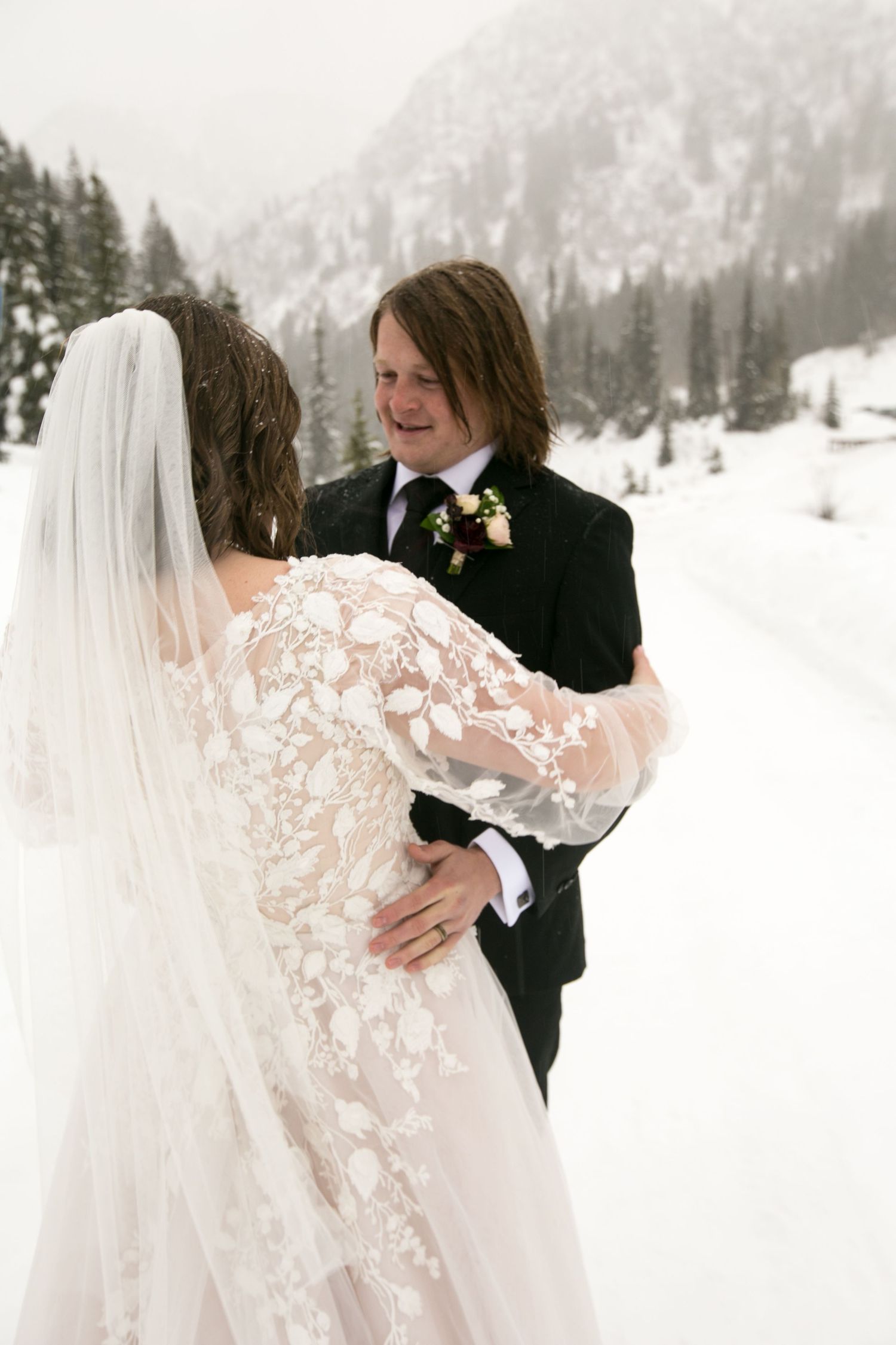 A winter wedding moment captured in snowy mountain scenery.