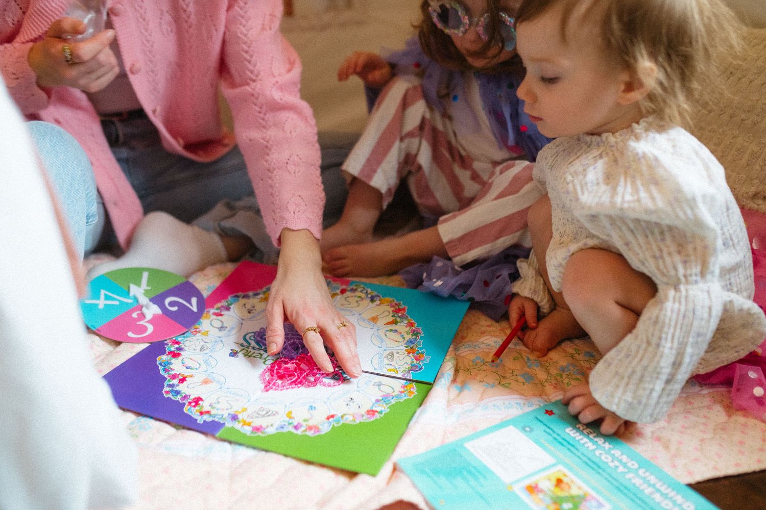 Young children engaged in creative art activity with colorful craft materials indoors.