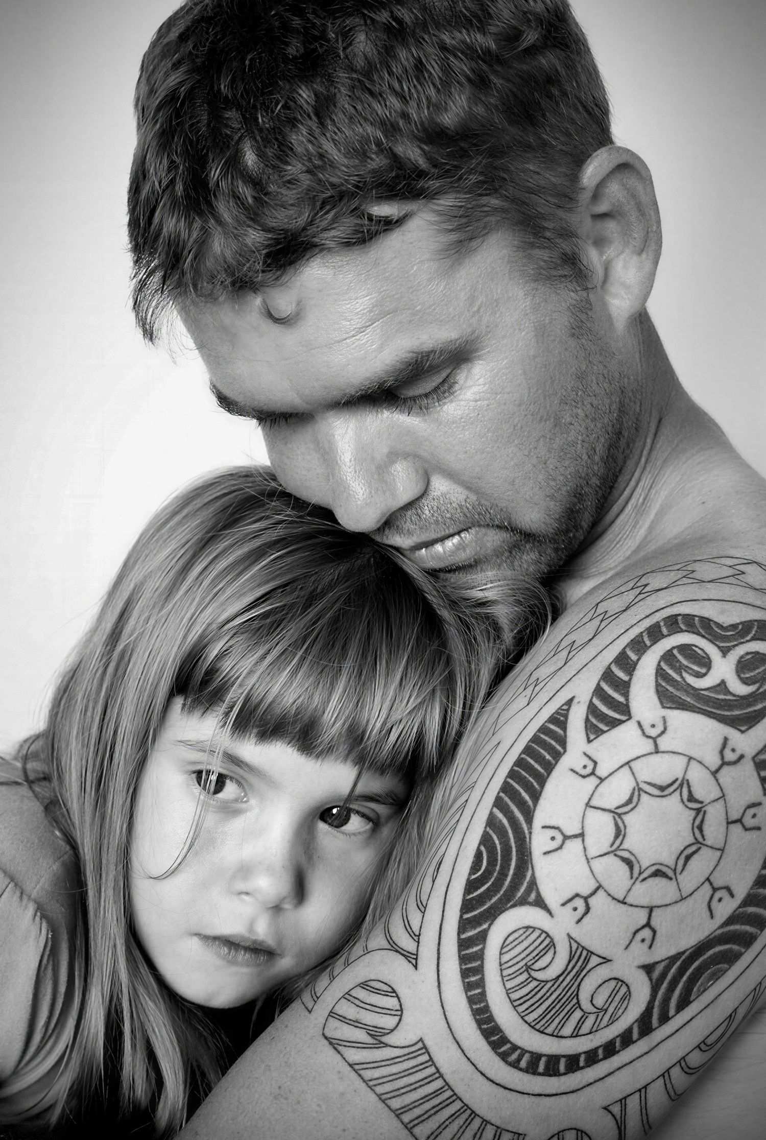 Black and white intimate portrait showing father and daughter