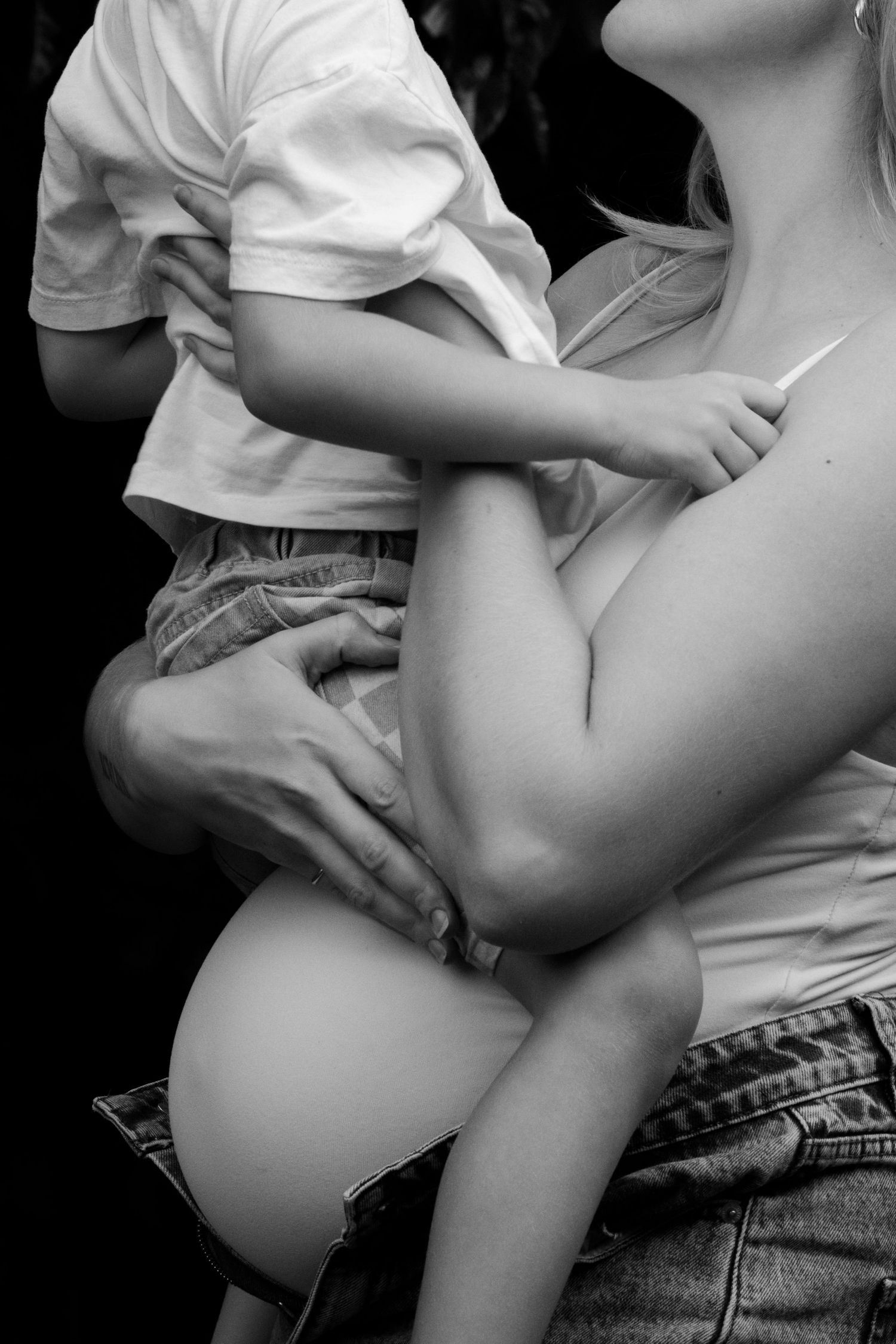 Black and white photo of a pregnant woman holding a young child, showcasing a beautiful maternity moment.