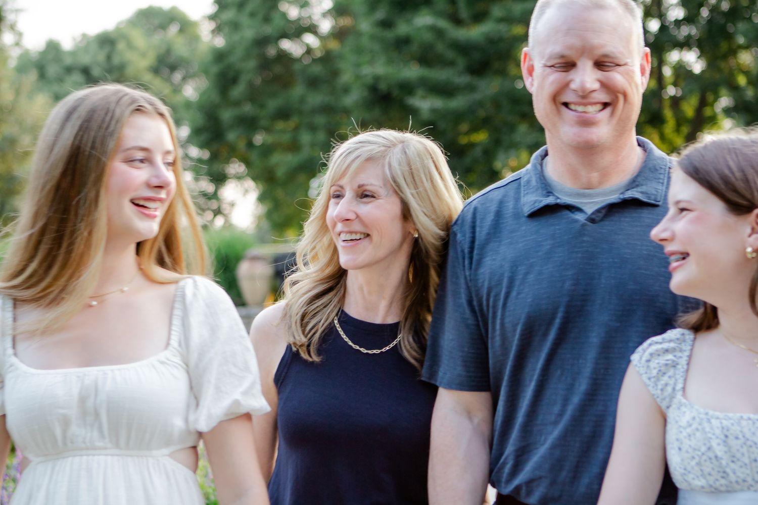 Group sharing genuine laughter during outdoor family photo session.
