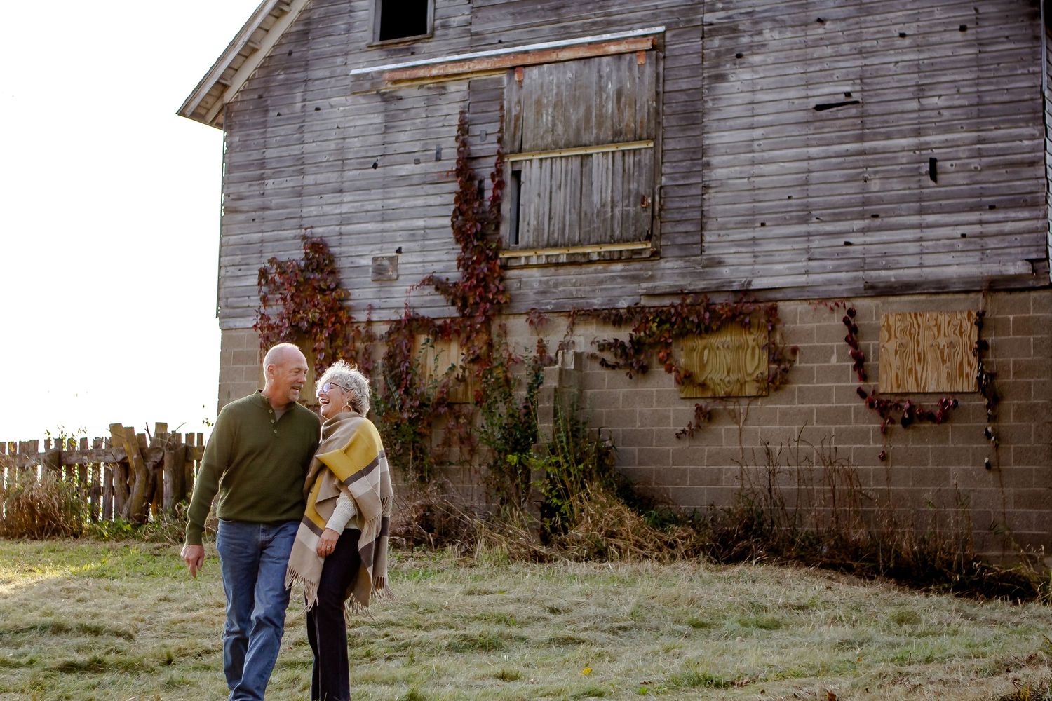 A couple laughs together during fall photo session in Oconomowoc