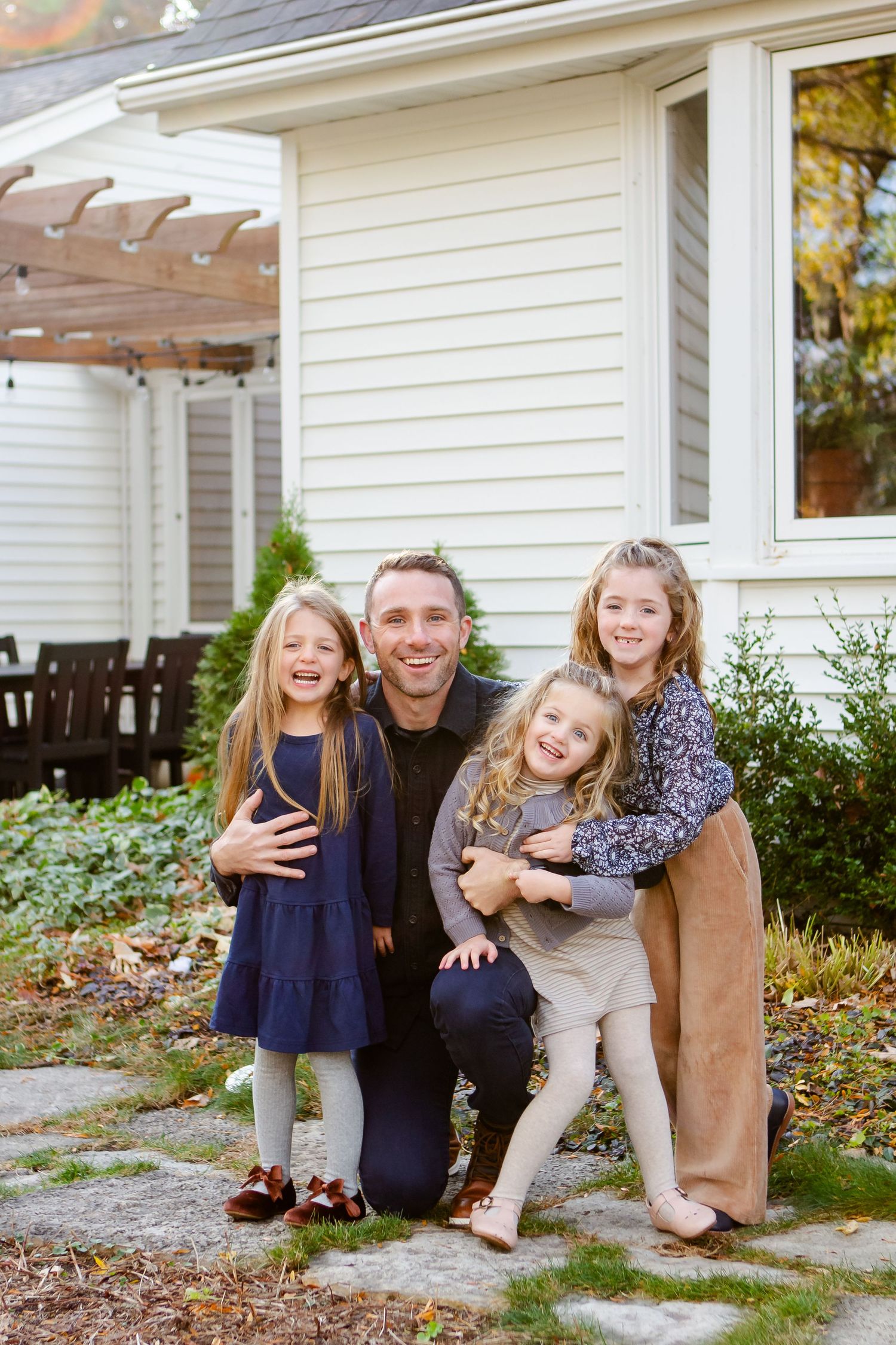 A family shares joyful moments together on their front porch during a fall photo session.