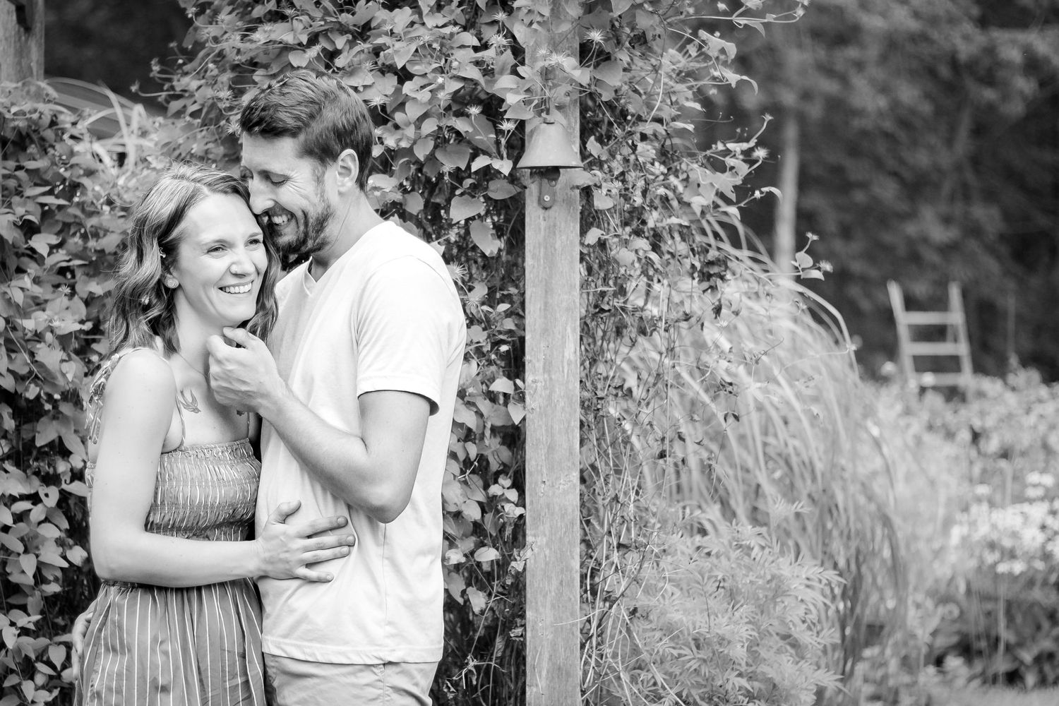 A couple shares a tender moment together in a garden setting during a black and white photo session at Delafield home session
