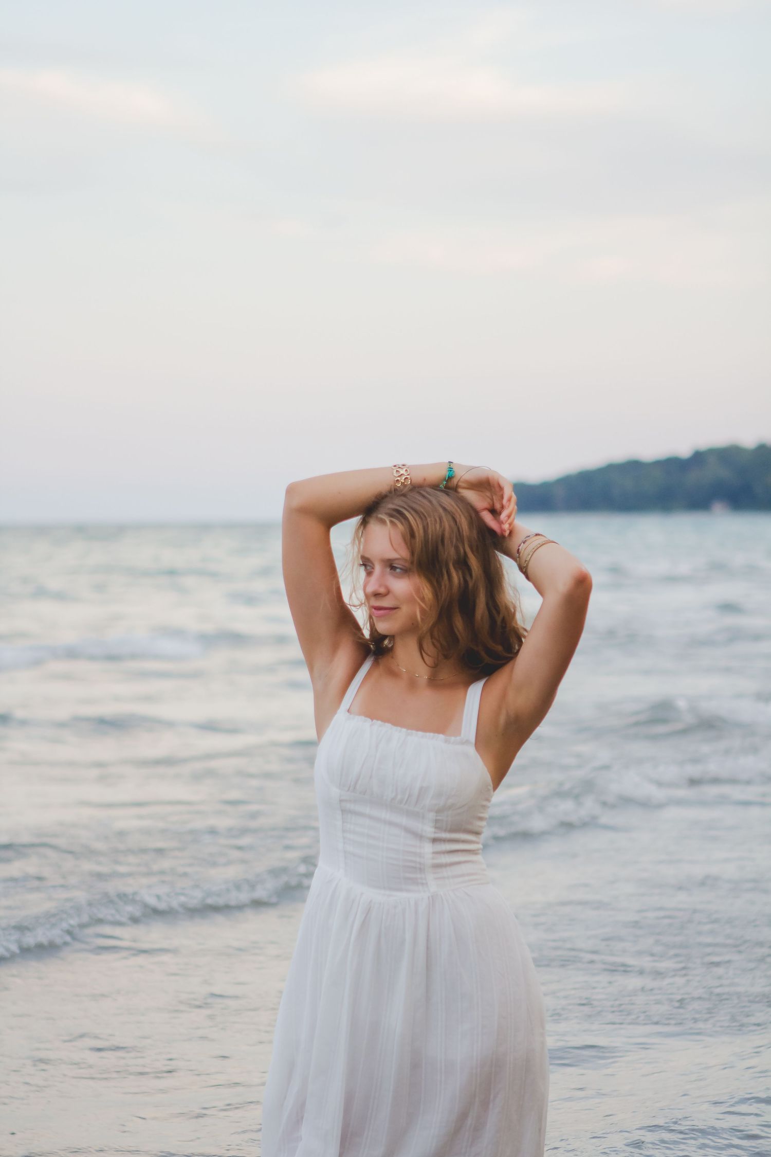 A dreamy beach portrait featuring a white dress against the ocean backdrop.