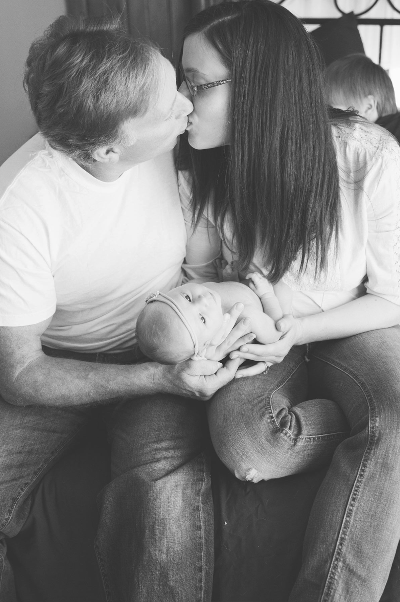 A series of black and white intimate photographs showing a couple in jeans sitting close together.