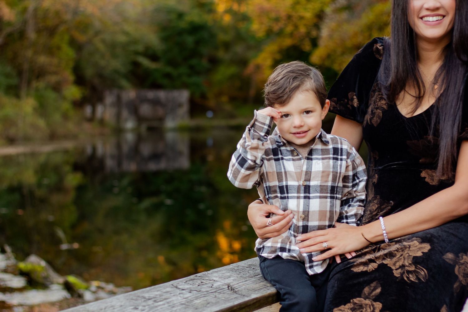 A candid autumn moment shared on a wooden bridge over a pond.