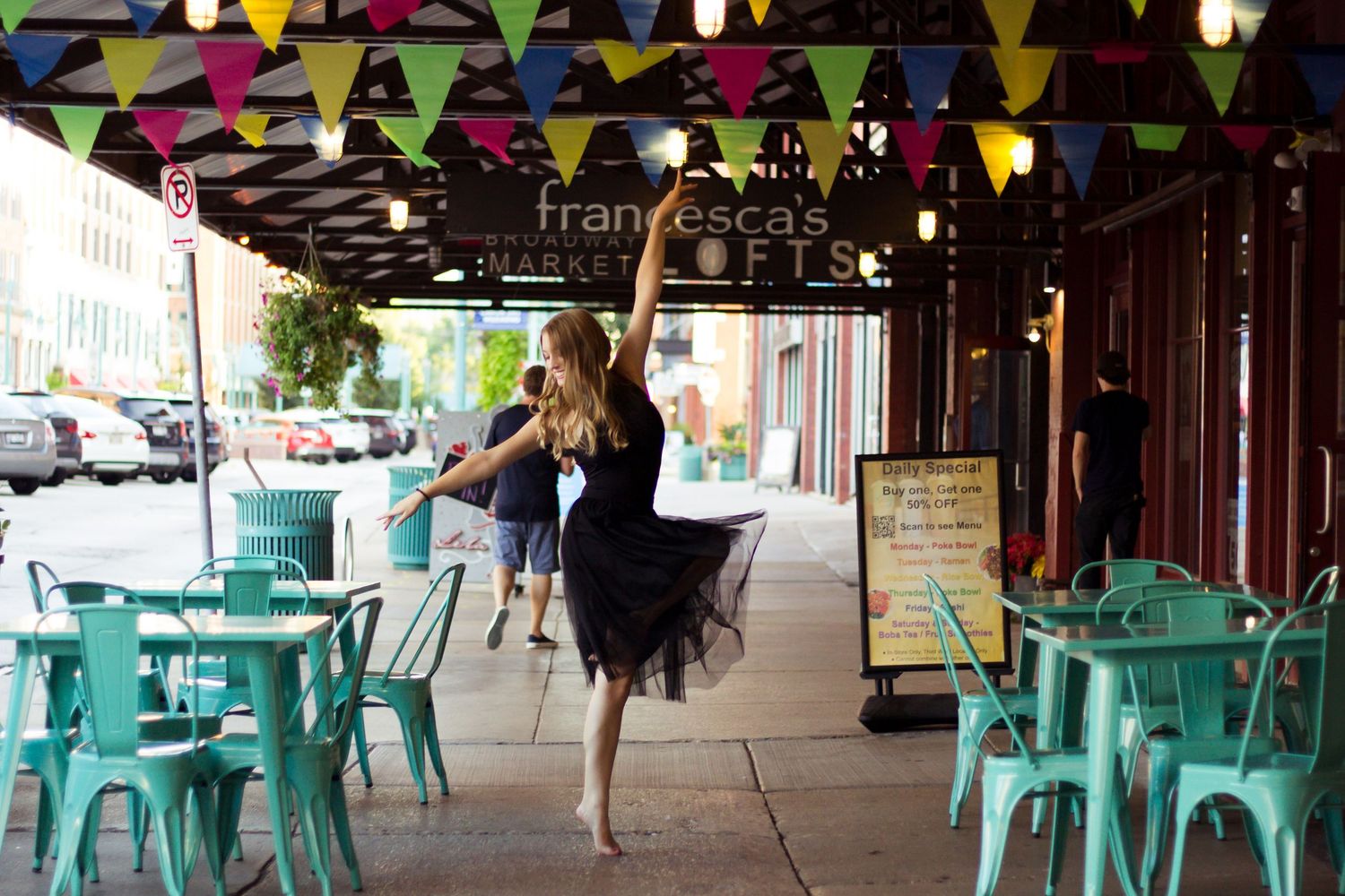 Colorful party bunting and turquoise chairs decorate an outdoor venue.