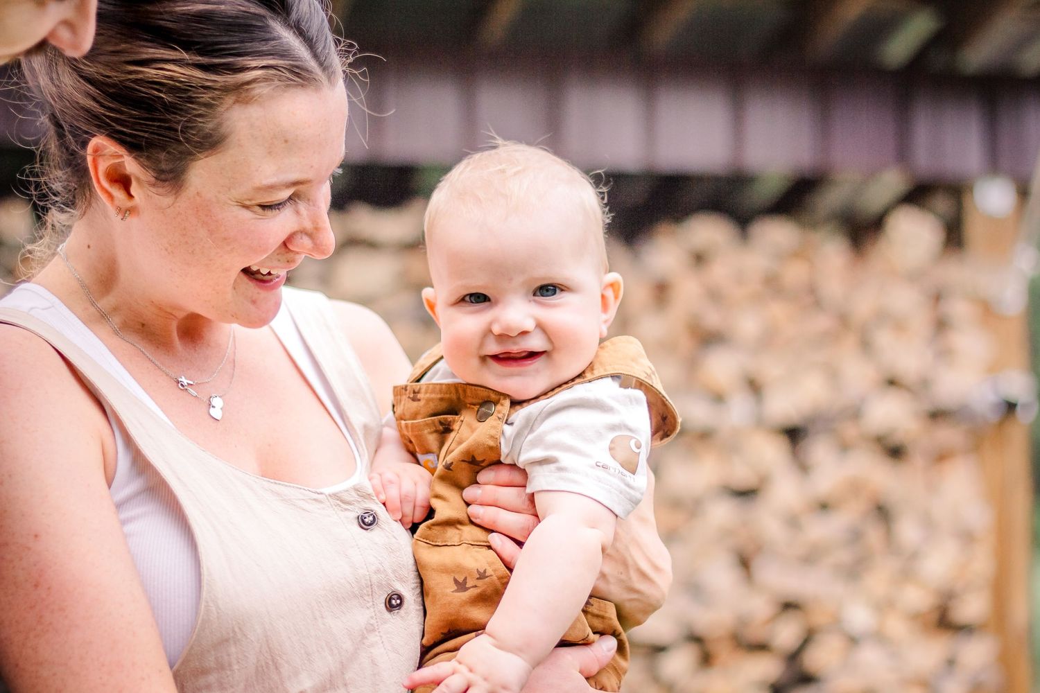 A mother and baby share tender moments together in a series of outdoor photographs with warm lighting.
