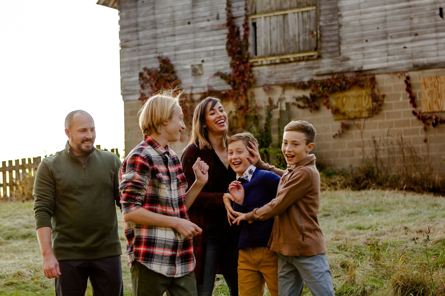 Rustic barn setting provides backdrop for casual family portraits.