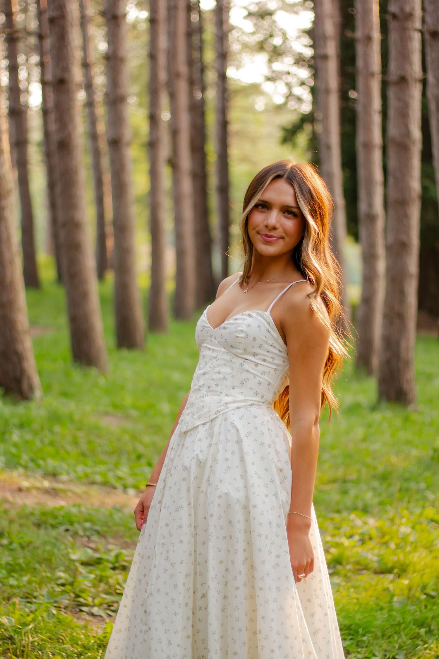 White dress photographed in forest setting with tall pine trees.