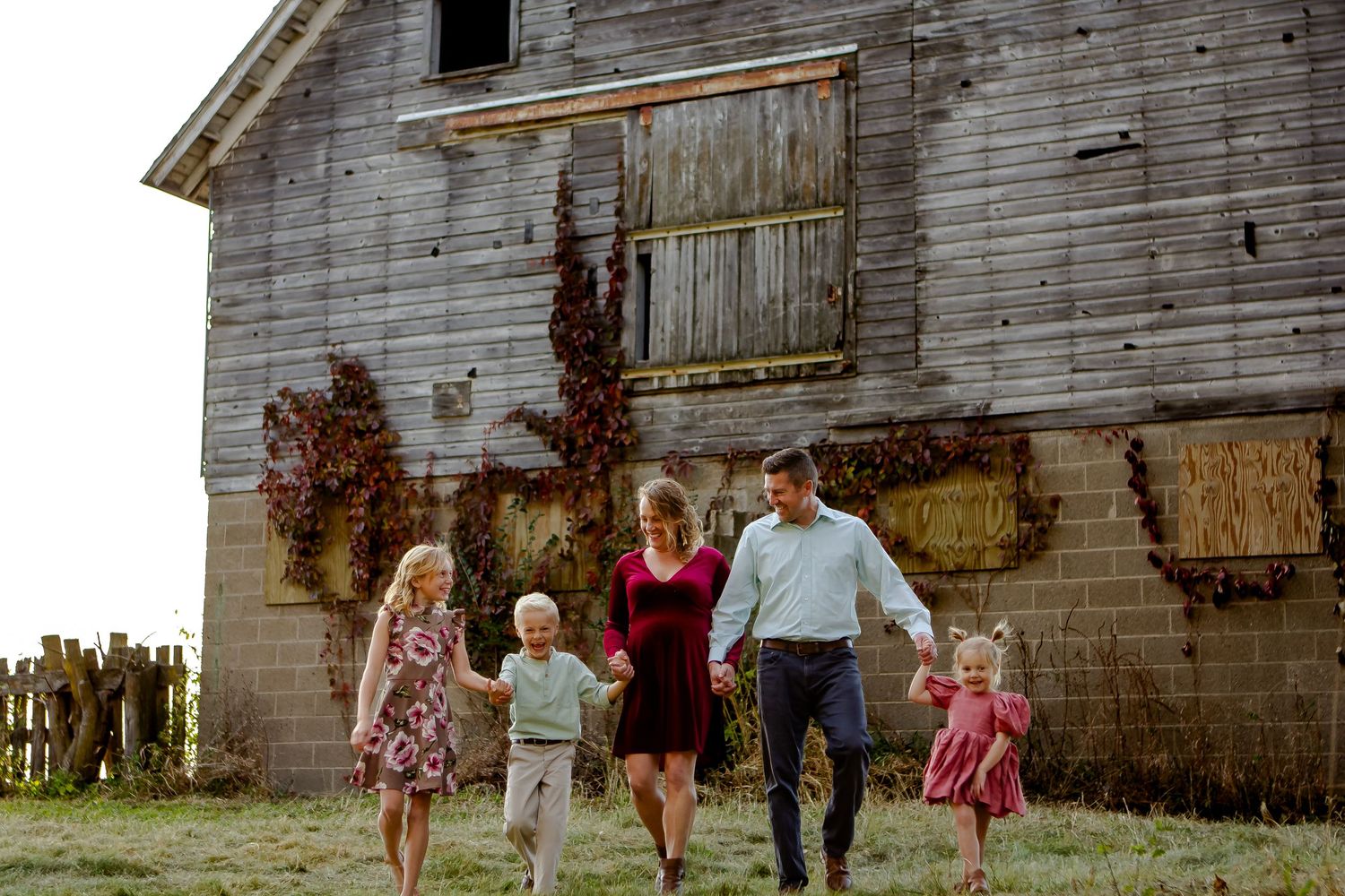 A family skips through a field during fall photo session in Oconomowoc