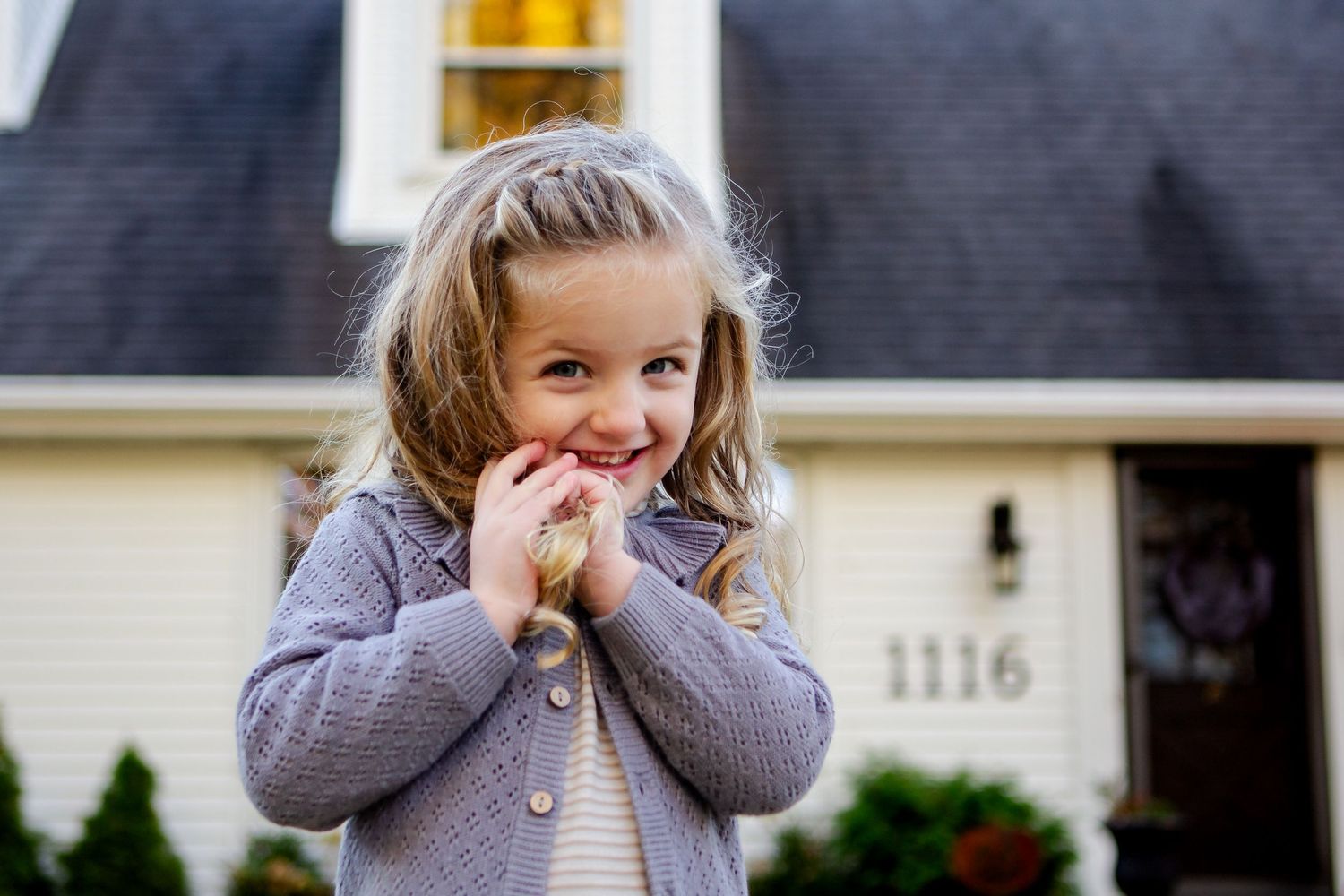 Young girl smiles and plays with hair during fall photo session