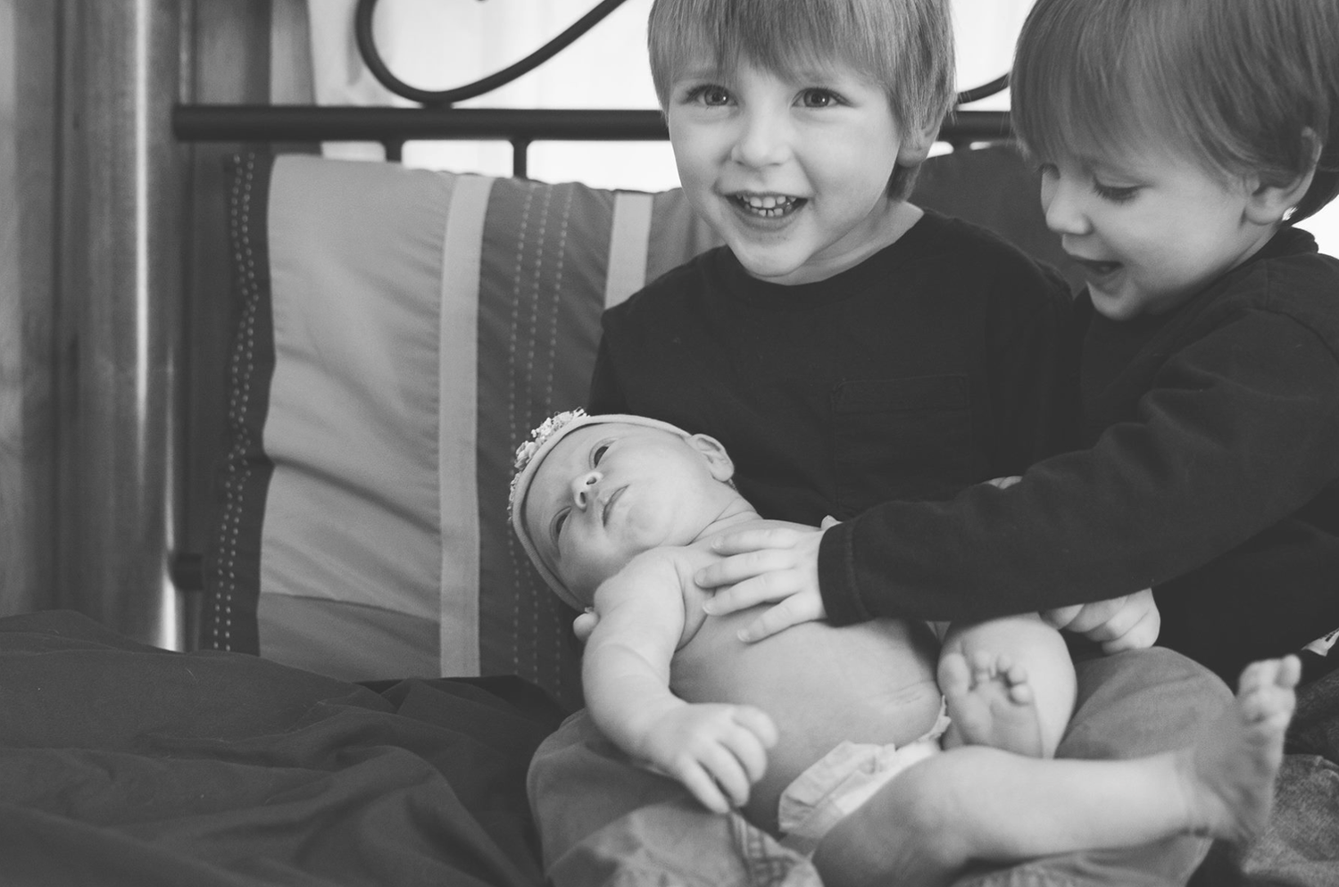 A series of black and white photos showing people holding and interacting with babies in various indoor settings.