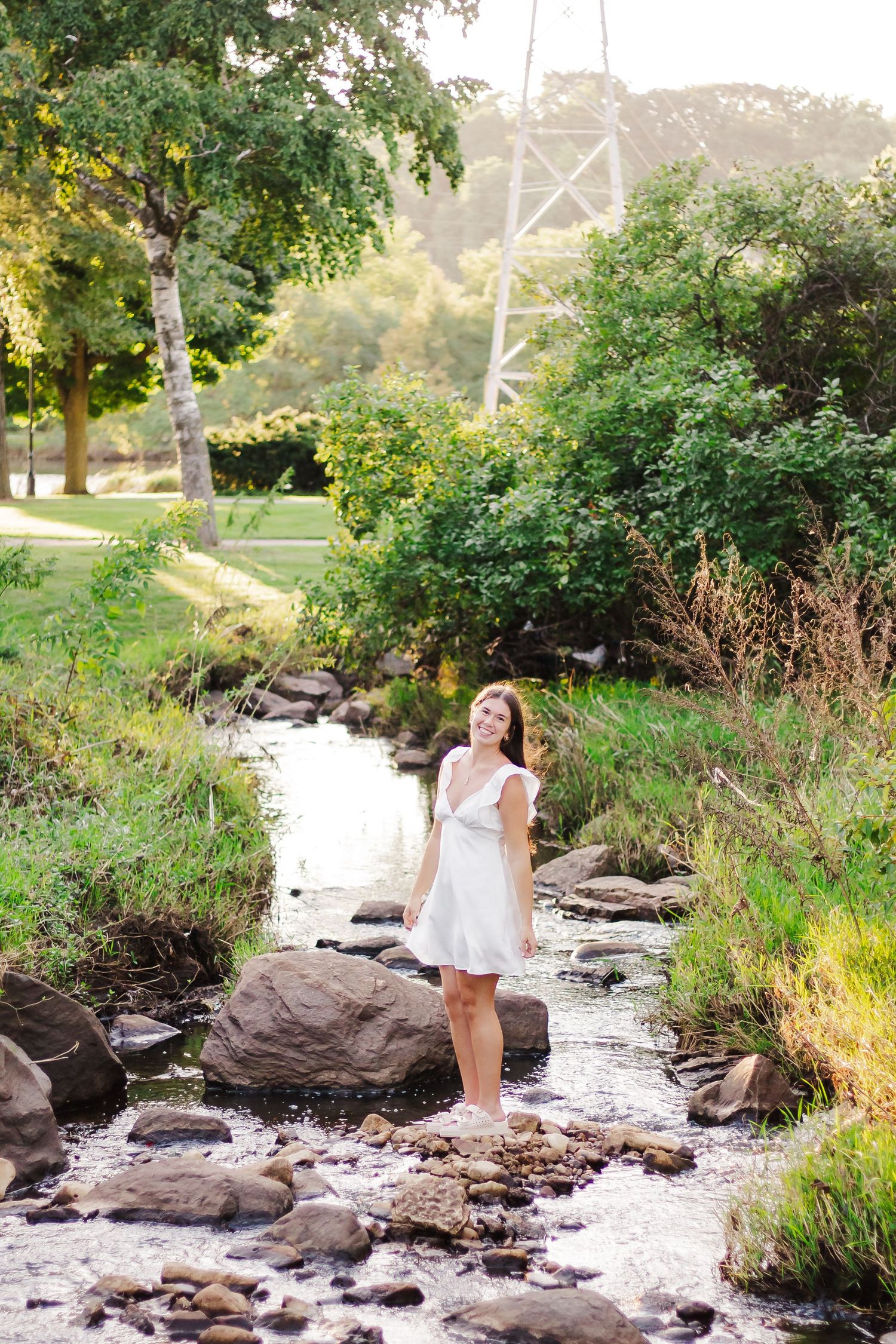 Natural creek setting with rocky terrain and flowing water surrounded by green vegetation.