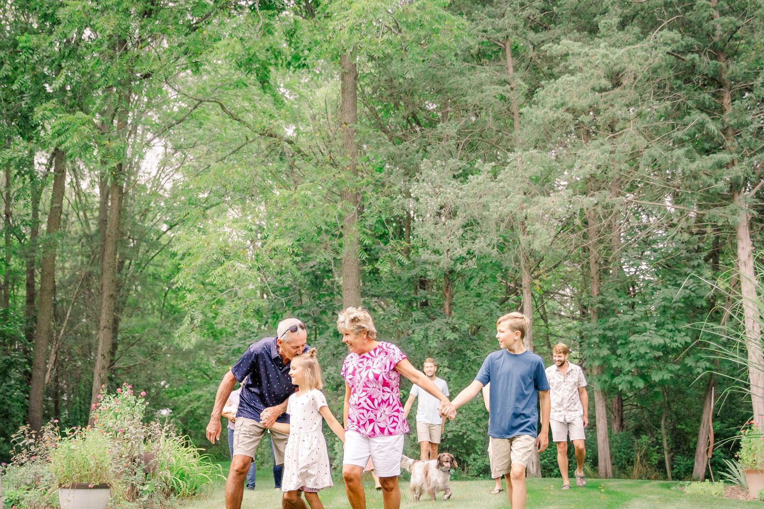 People walking on a wooded path through lush green trees and foliage during a summer day at Delafield home session