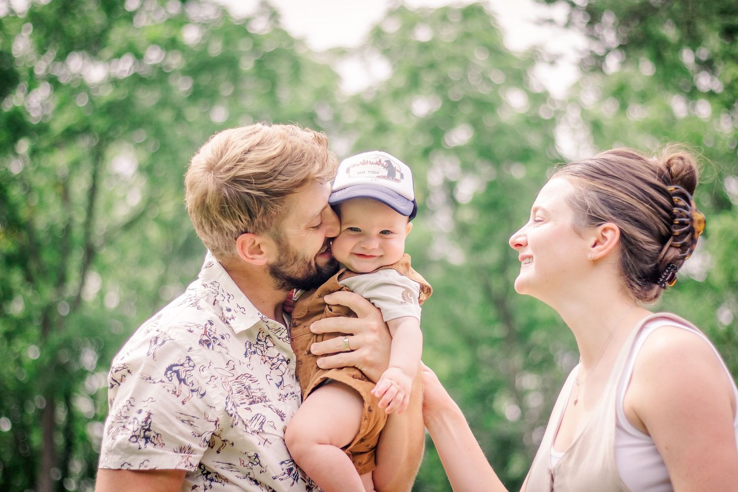 A family shares a joyful moment together outdoors in a green summer setting during a Delafield photo session