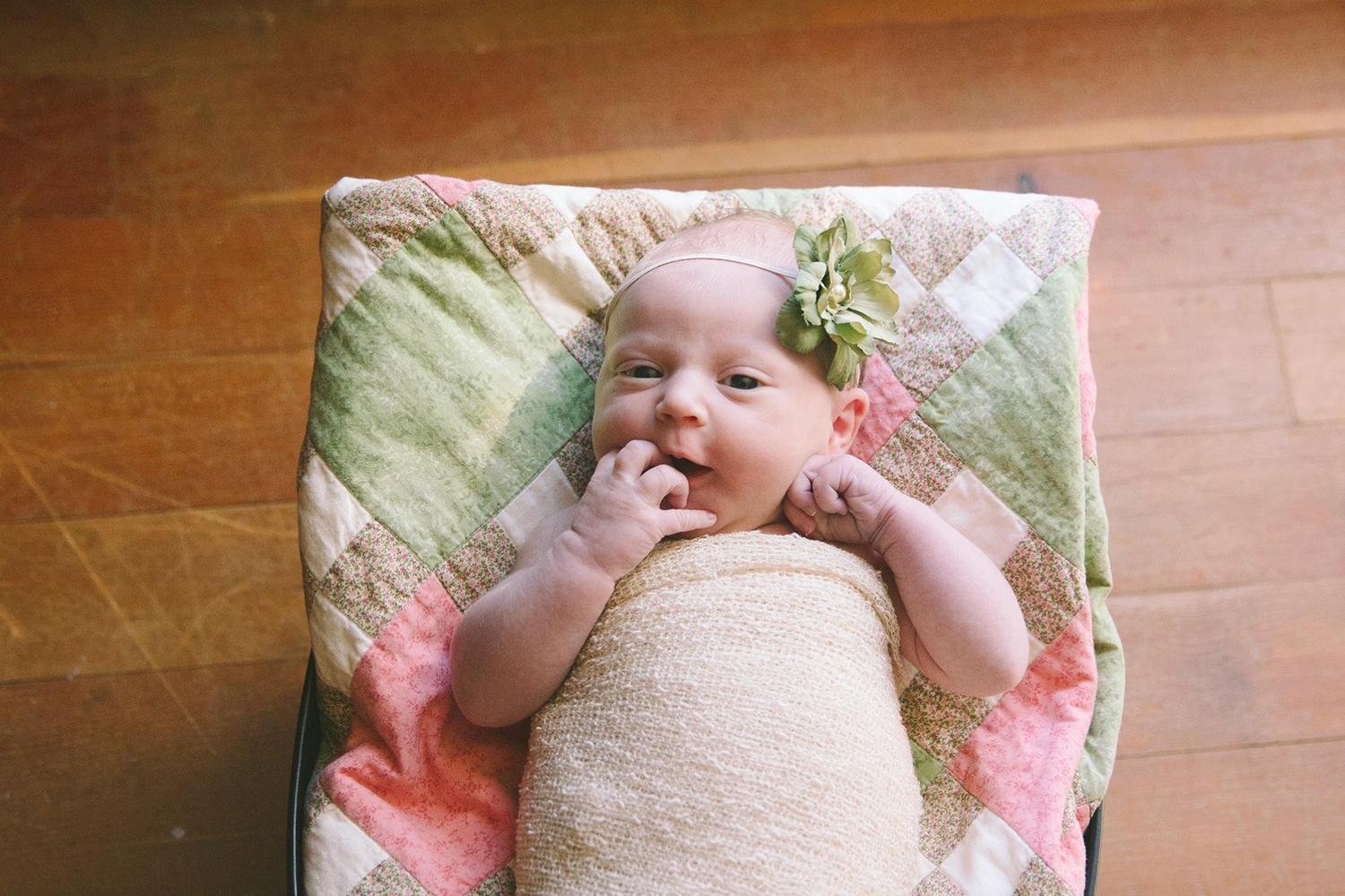 A series of seven photos showing a baby lying on pink floral bedding wearing a white onesie and headband.