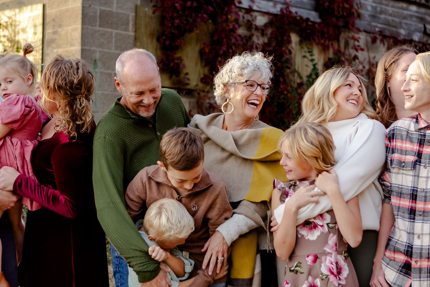 Grandparents and grandkids laugh and hug during fall photo session in Oconomowoc