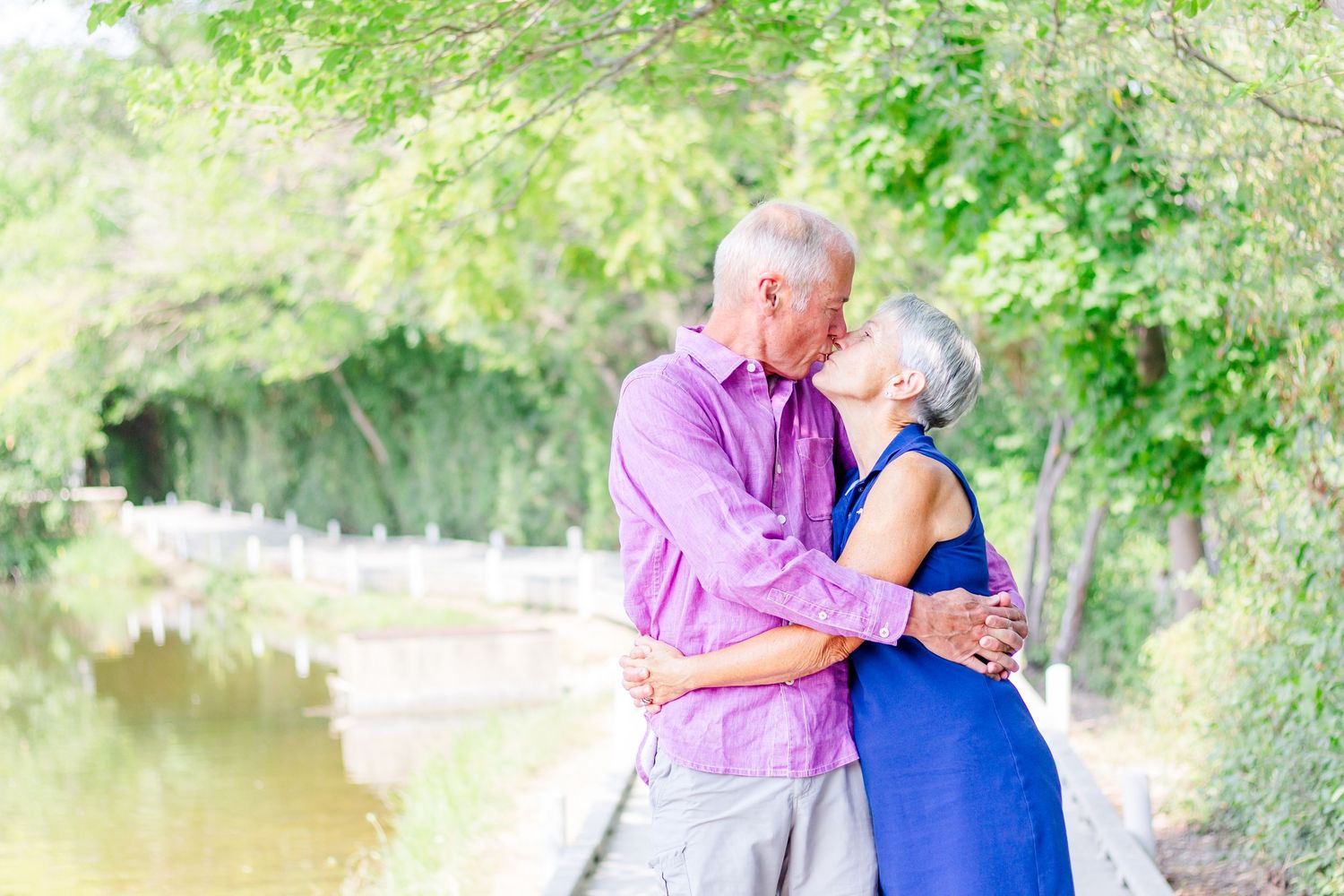 Family members sharing tender moments on a tree-lined walking path.