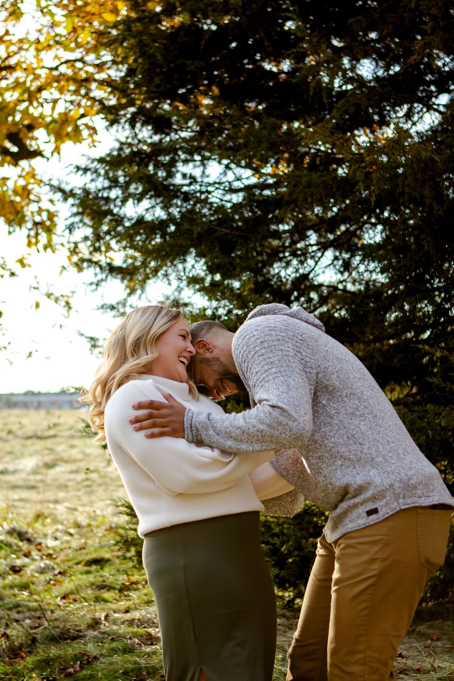 A couple is playfully laughing during fall photo session in Oconomowoc