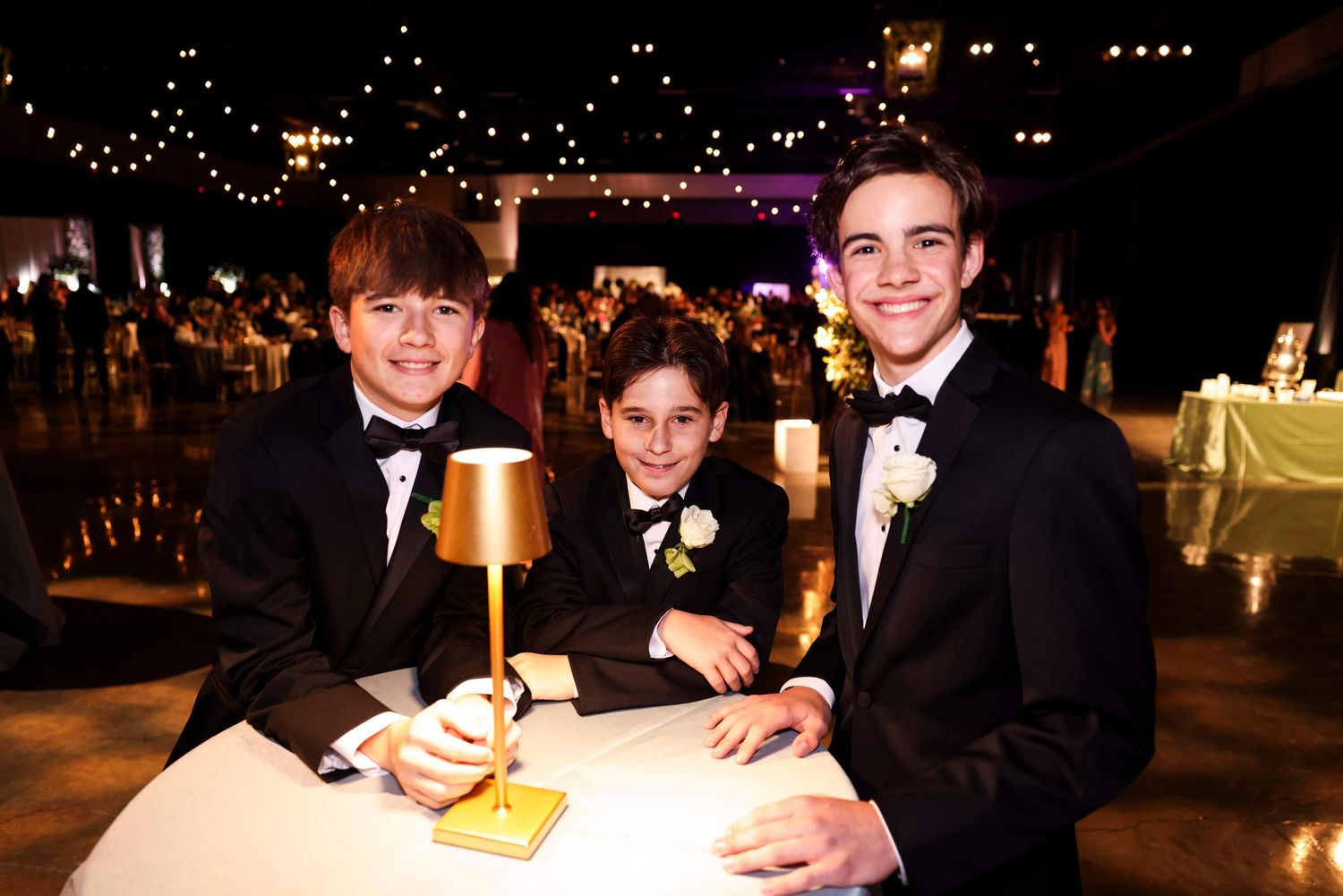 A series of candid moments at an elegant evening wedding reception with guests in formal attire and twinkling lights.