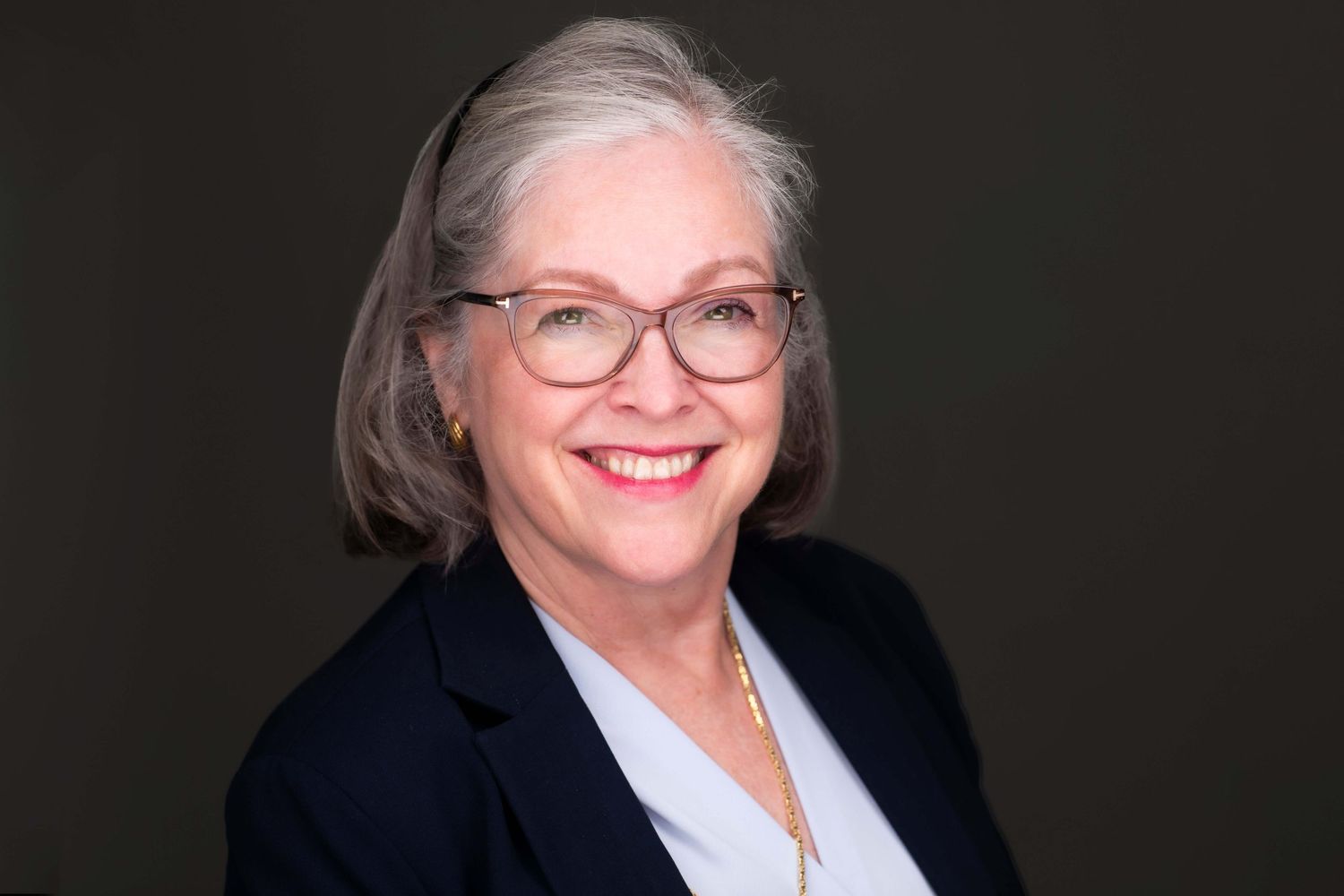Professional headshots of senior executives in business attire against dark backdrop.