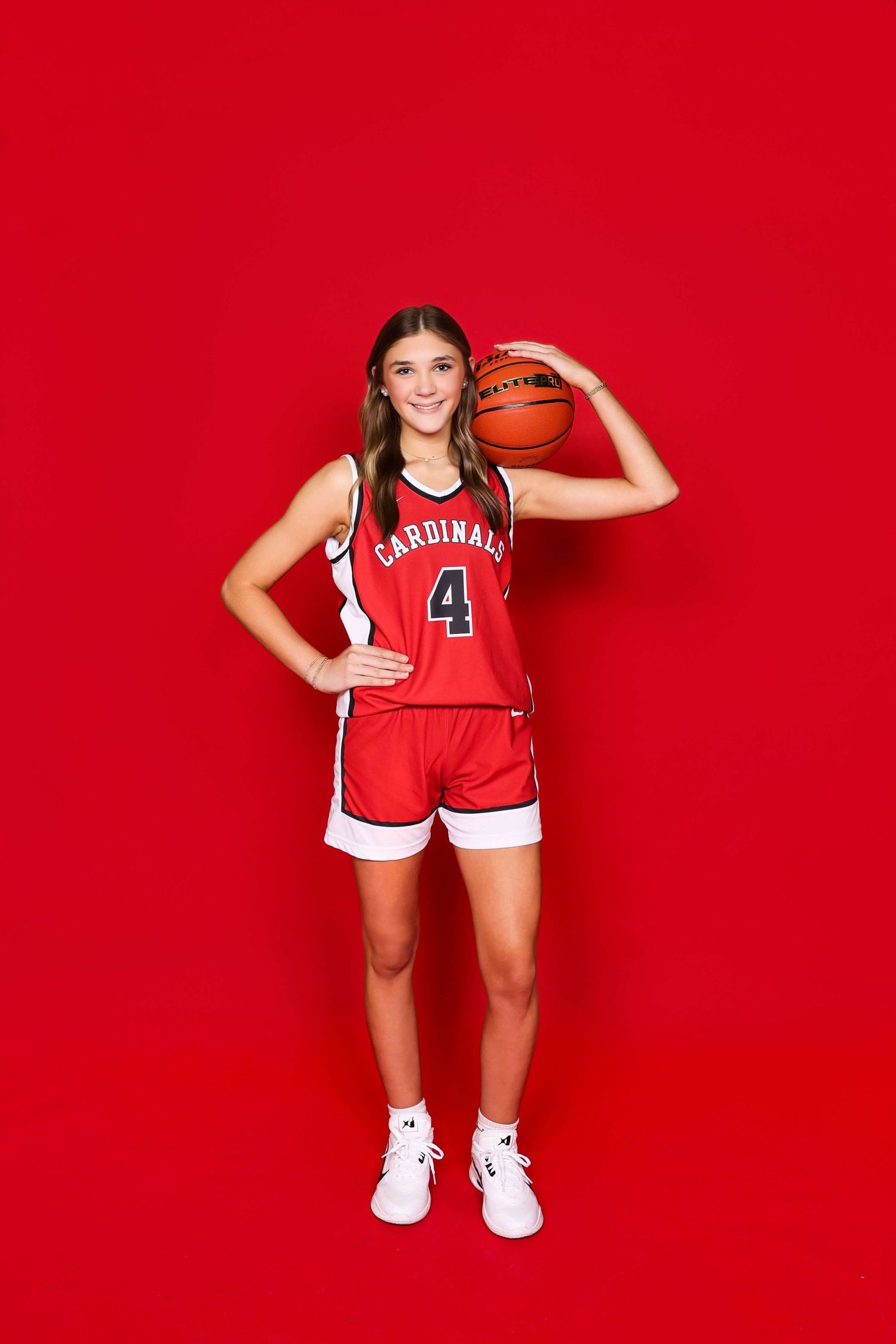 Basketball player in red Cardinals jersey shows dynamic poses during photo session.