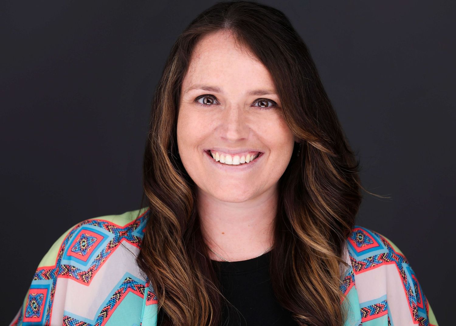 Professional headshots featuring colorful patterned clothing against black background.