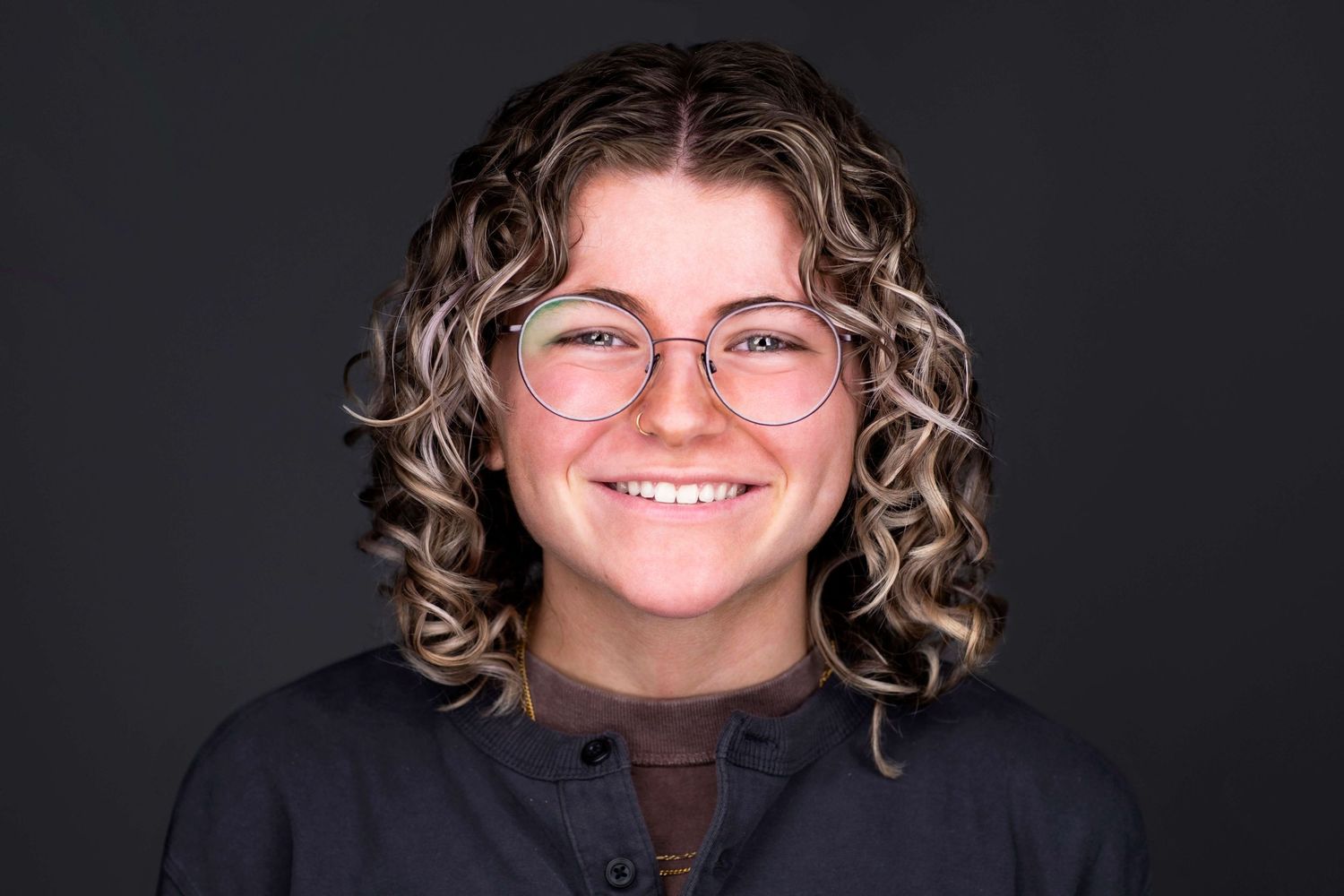 Studio portrait series showing progressive facial expressions against dark background.