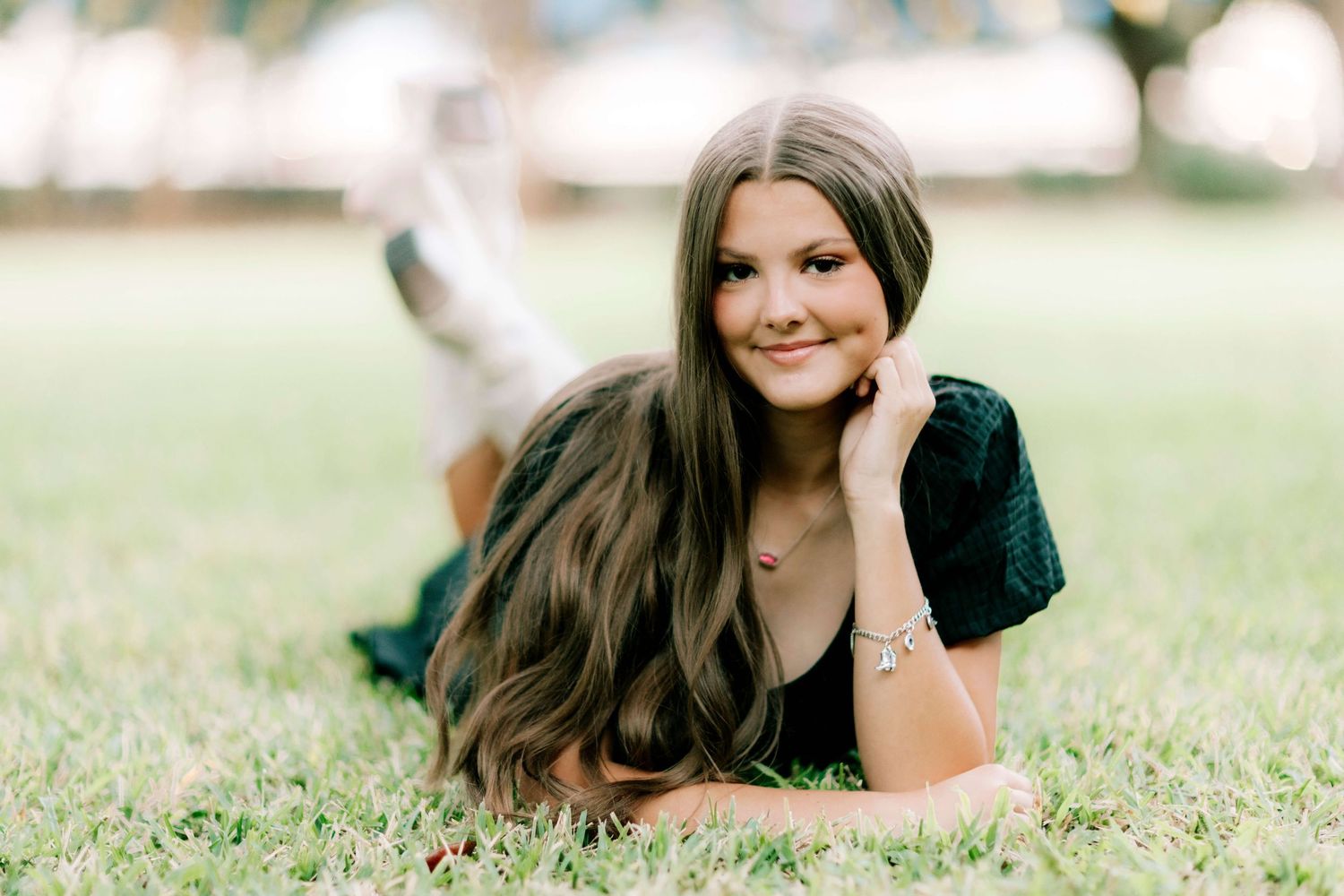 Casual outdoor portrait session on grass with natural lighting and relaxed poses.