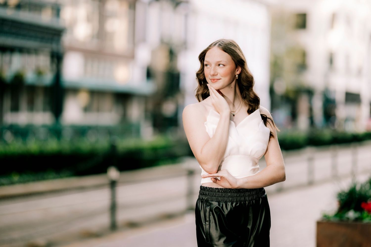 Urban portrait session with modern architecture and city buildings in background.