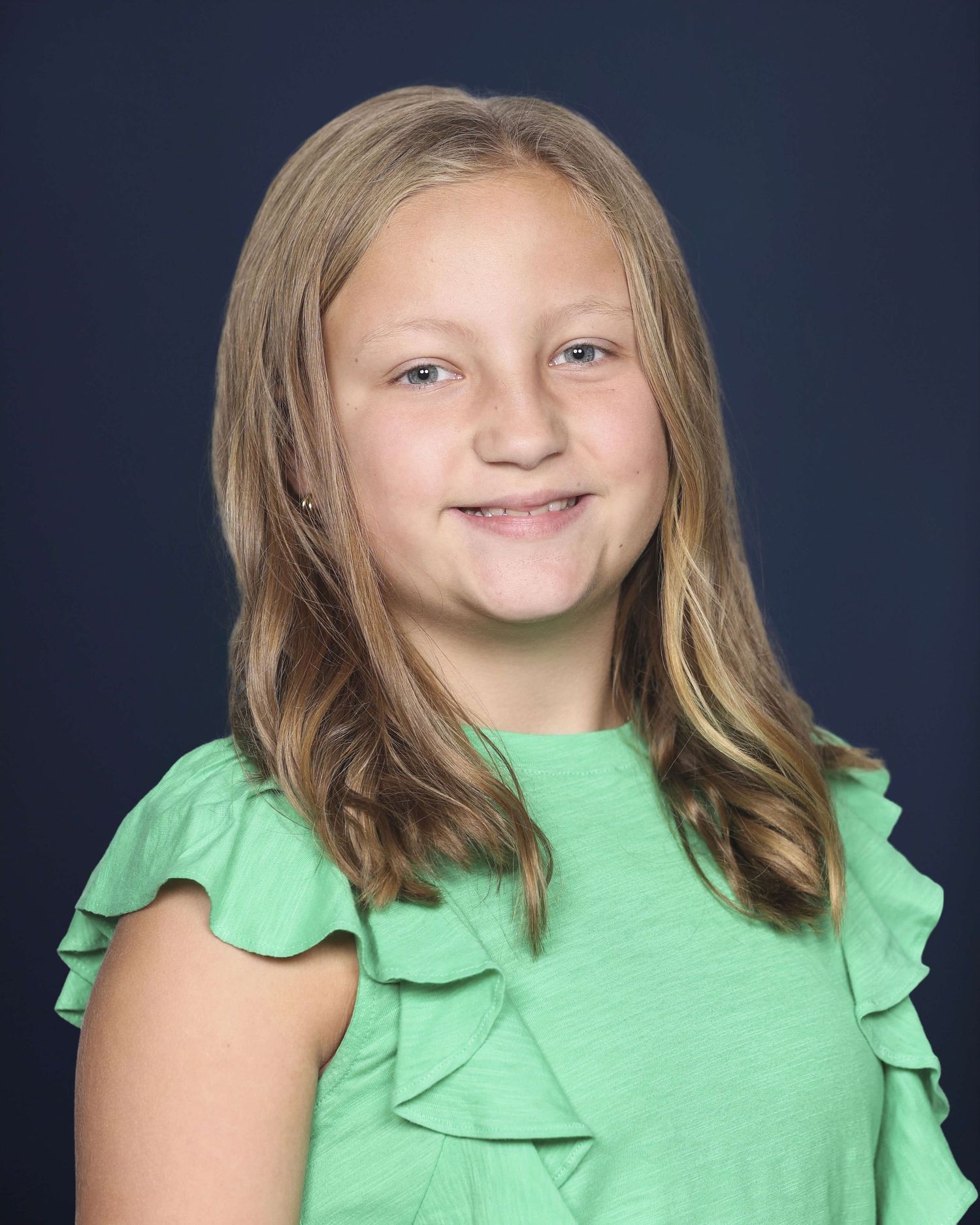 A series of photos showing someone in a mint green ruffled top against a dark background.