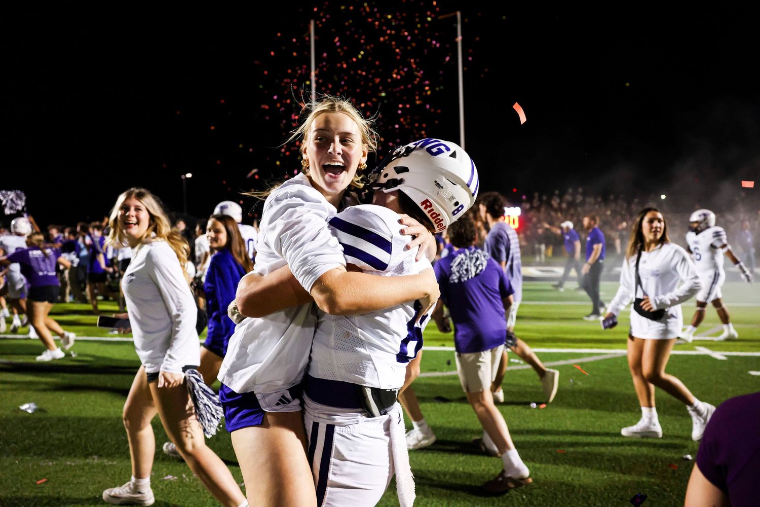 Victory celebration on football field with cheerleaders and players.