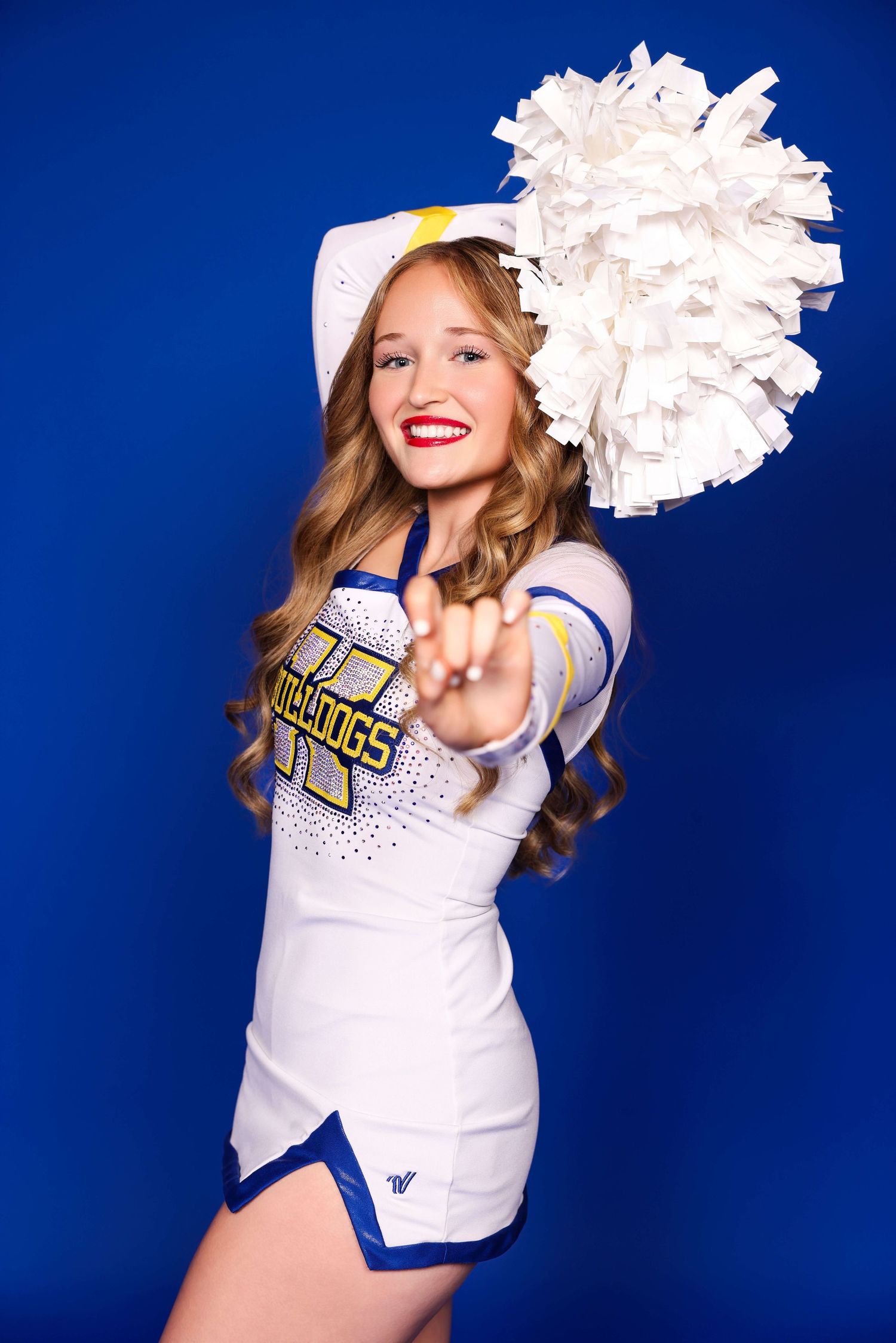 Cheerleader in white uniform with pom poms performs energetic poses against blue background.