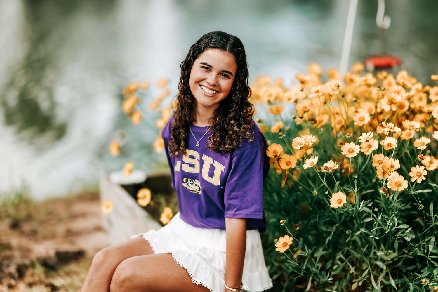 College graduation photos with purple academic regalia among blooming flowers.