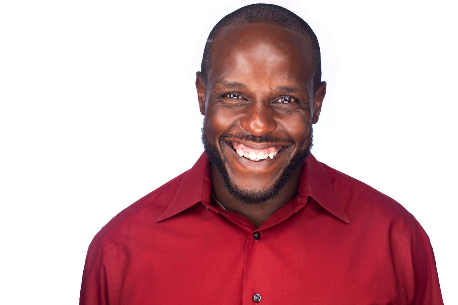 Cheerful professional in red polo shirt against white background.