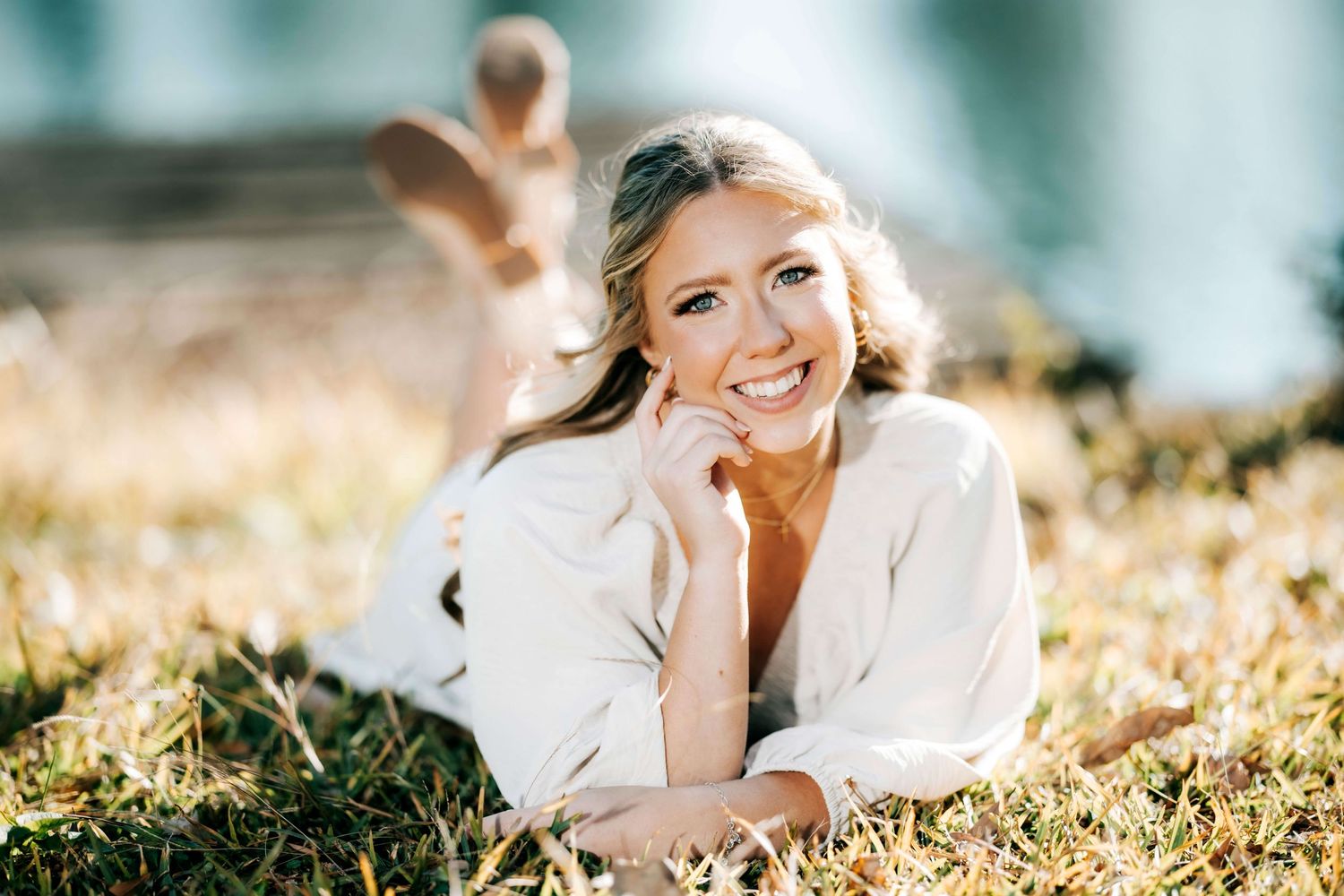 Sunlit outdoor portrait session in a grassy meadow with soft natural lighting.