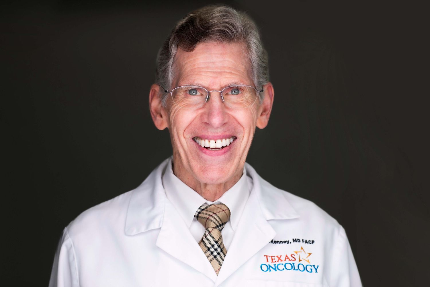 Healthcare professionals in white coats smiling against dark studio background.