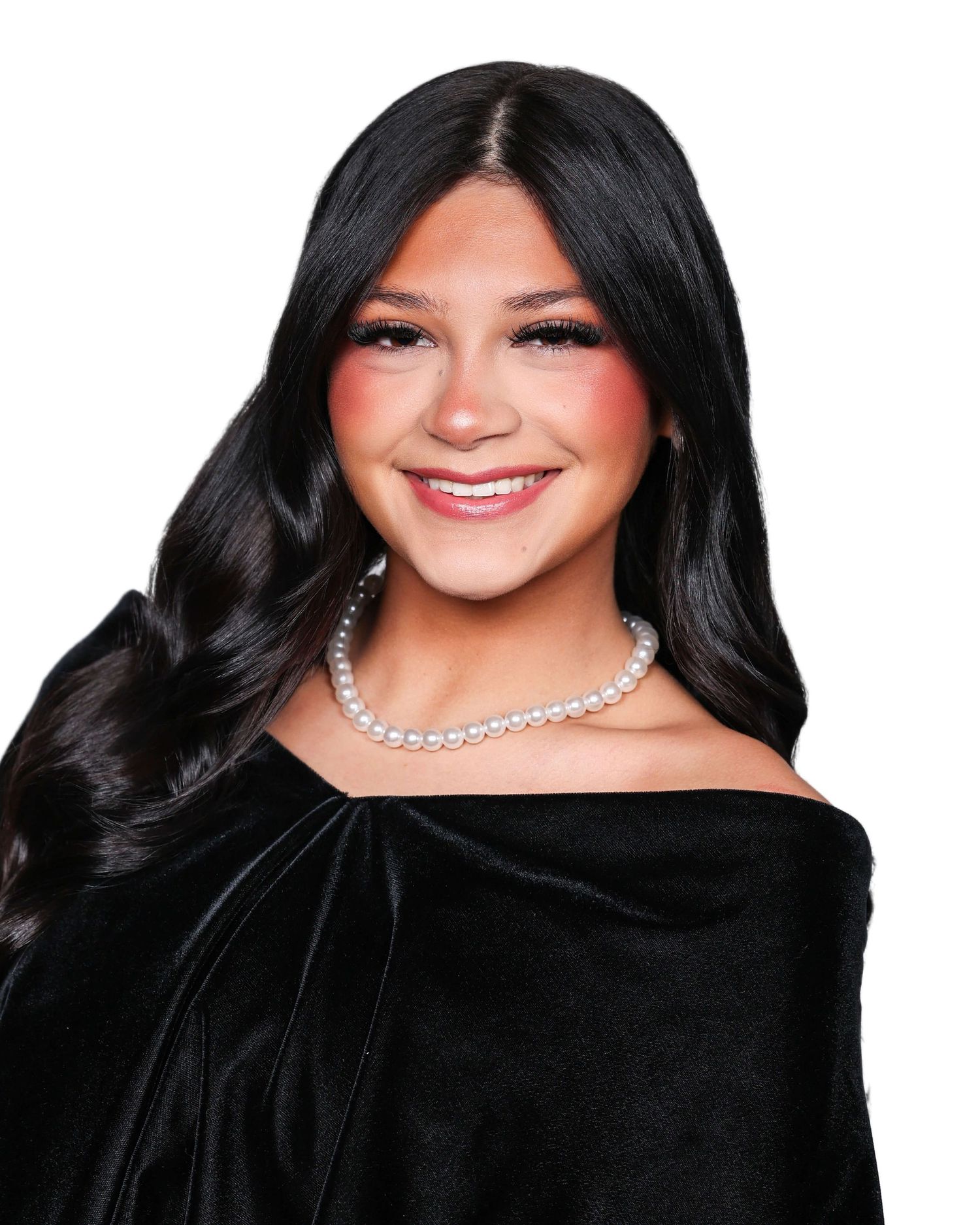 A woman with long dark hair and a diamond necklace poses in a black dress against a dark background.
