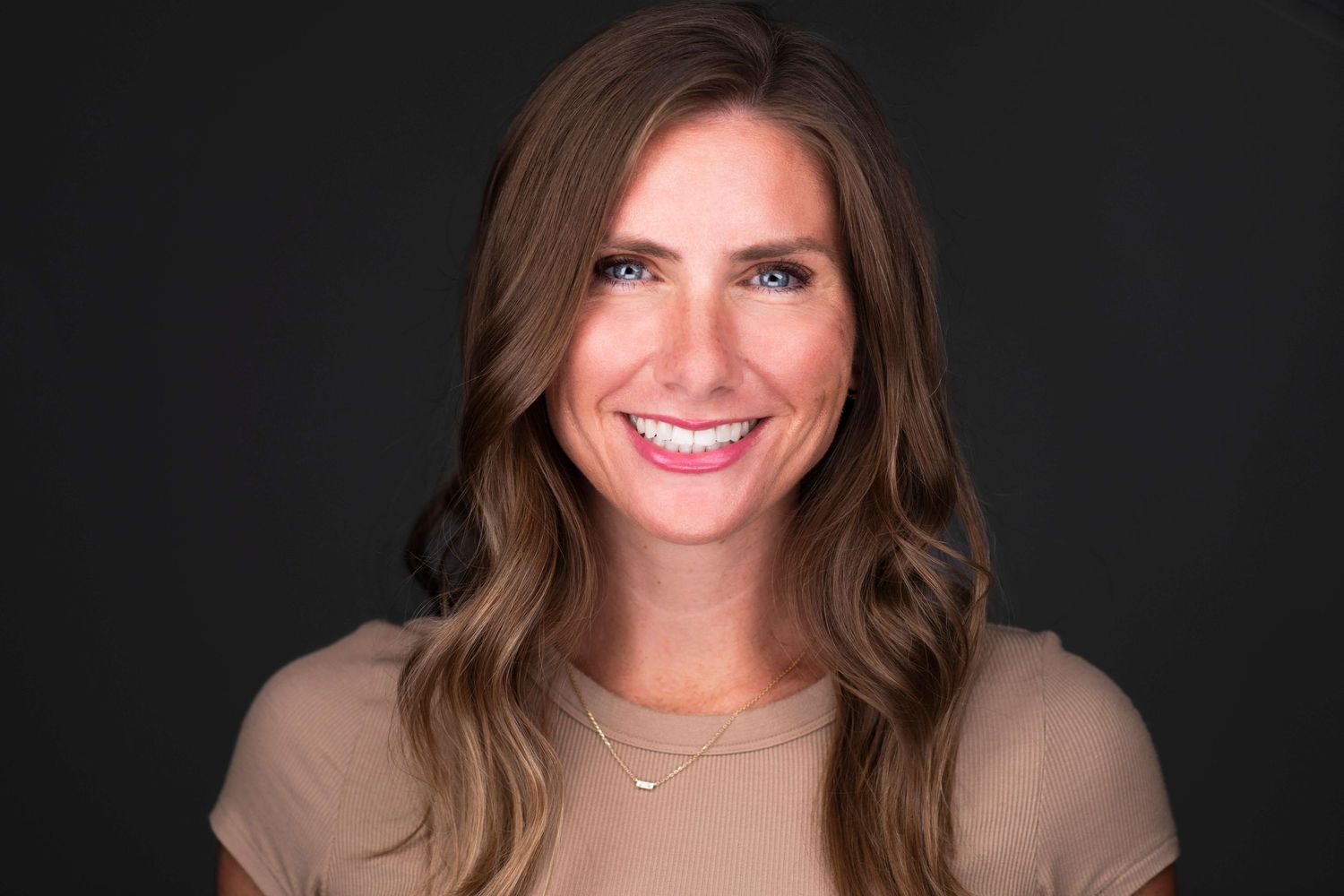 Professional headshot portraits against dark background showing warm smiles and business attire.