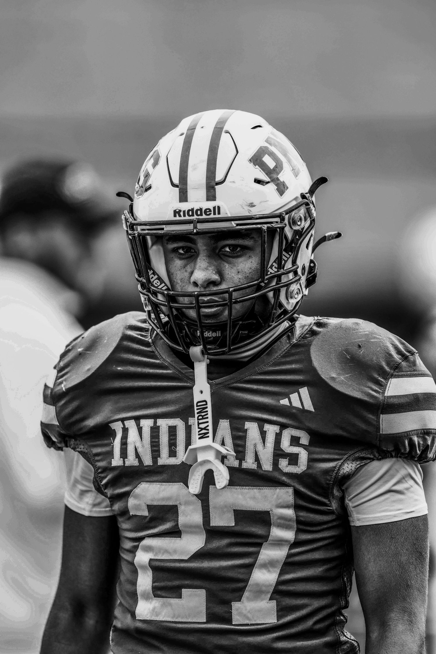 Football players in Indians jerseys lined up on the sideline during a game.