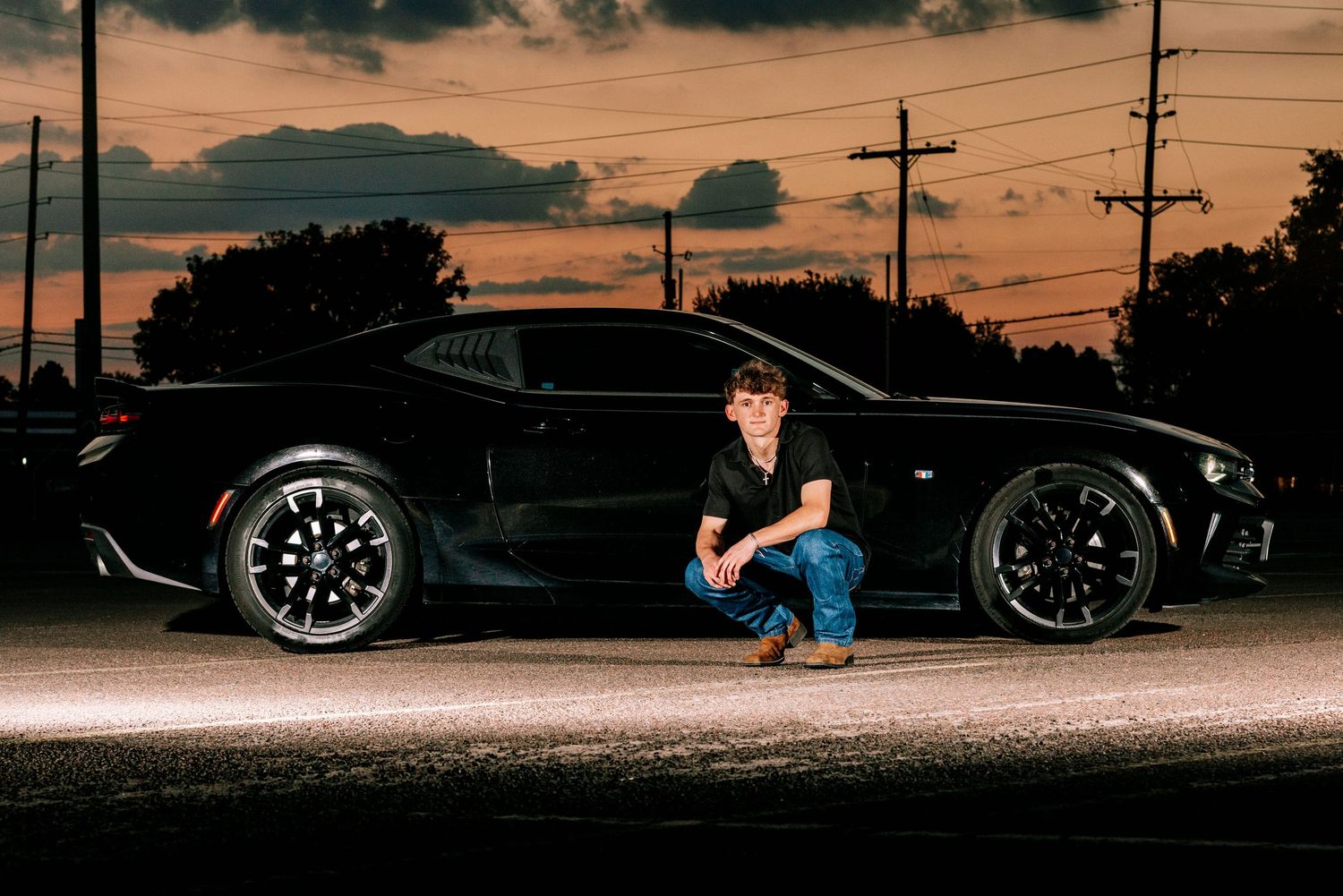Dramatic sunset silhouette photo shoot with cars and power lines.