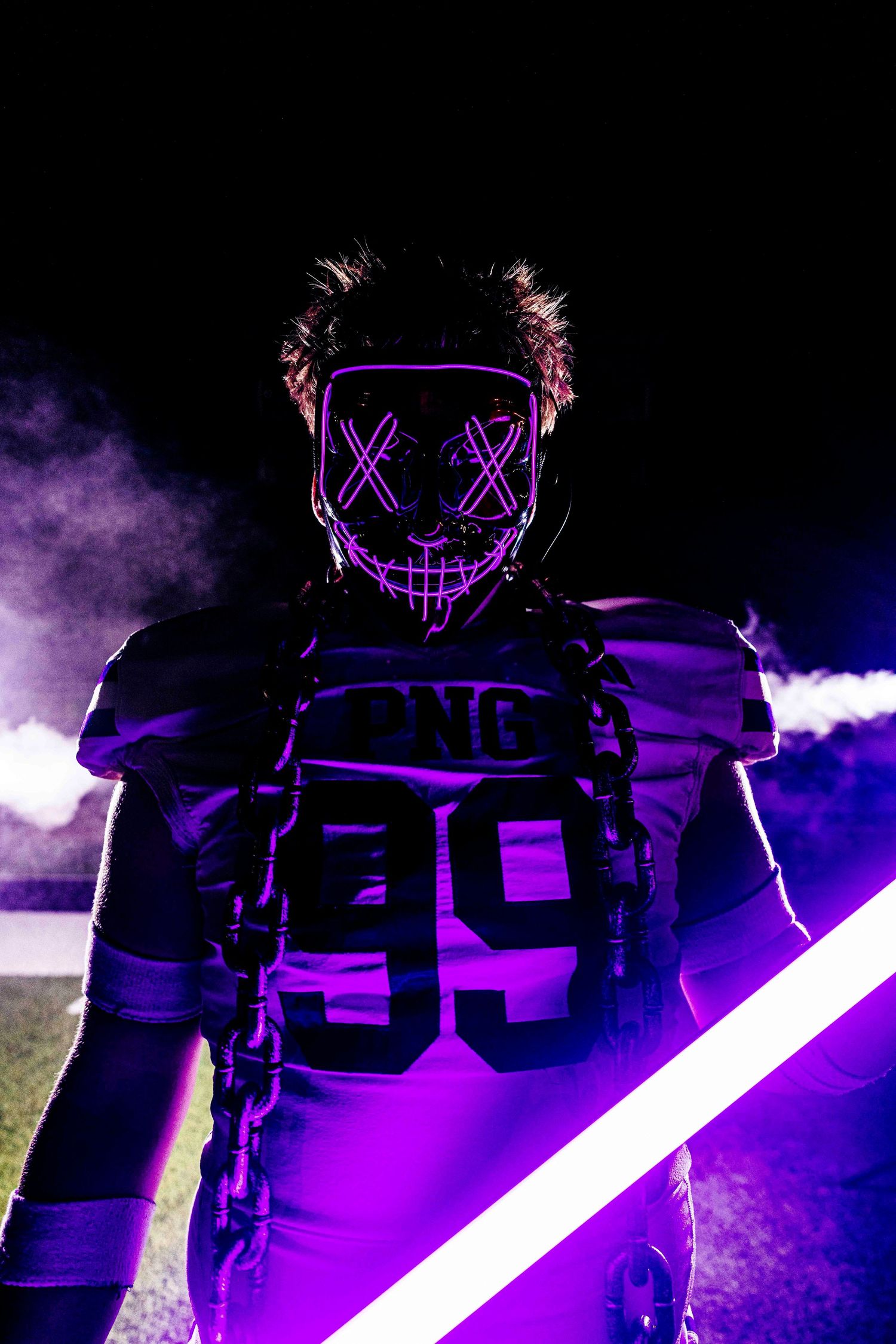 Dramatic purple-lit sports photo with glowing LED lights and smoke effects.