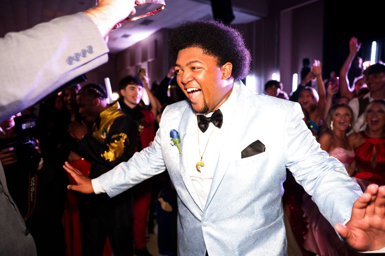 A wedding reception dance party with guests celebrating on the dance floor as a performer in white entertains the crowd.