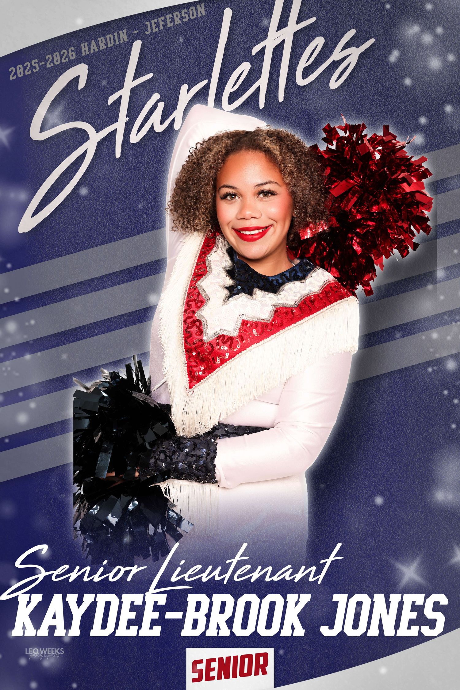 Cheerleader in white winter outfit with red and black pom poms poses against snowy blue backdrop for senior photos.