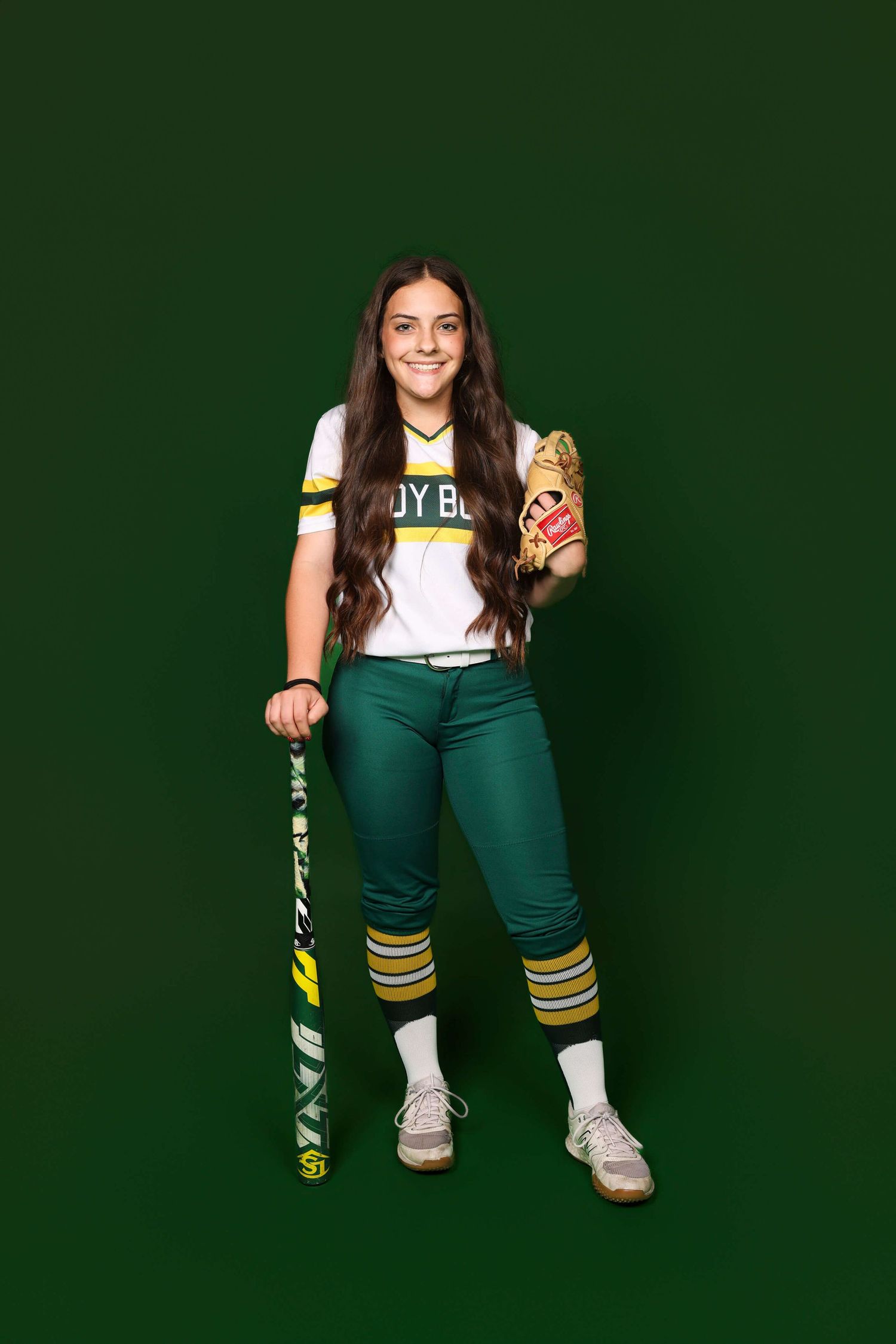 Person wearing a white and green varsity uniform poses against dark green background showing different angles of outfit.
