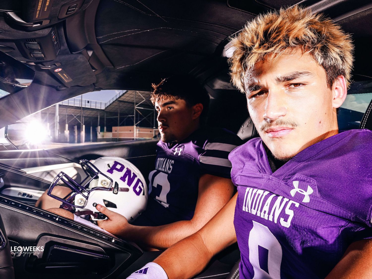 Athletes in purple uniforms pose inside a vehicle during team photoshoot.