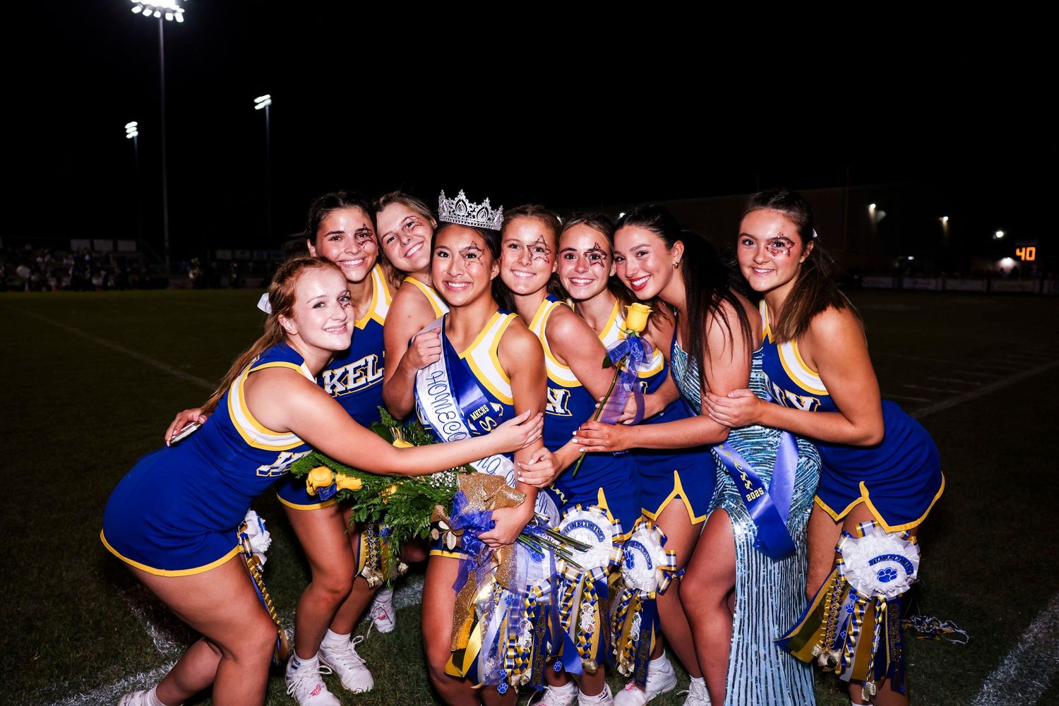 Cheerleaders in blue and white uniforms pose together in multiple group photos at night.